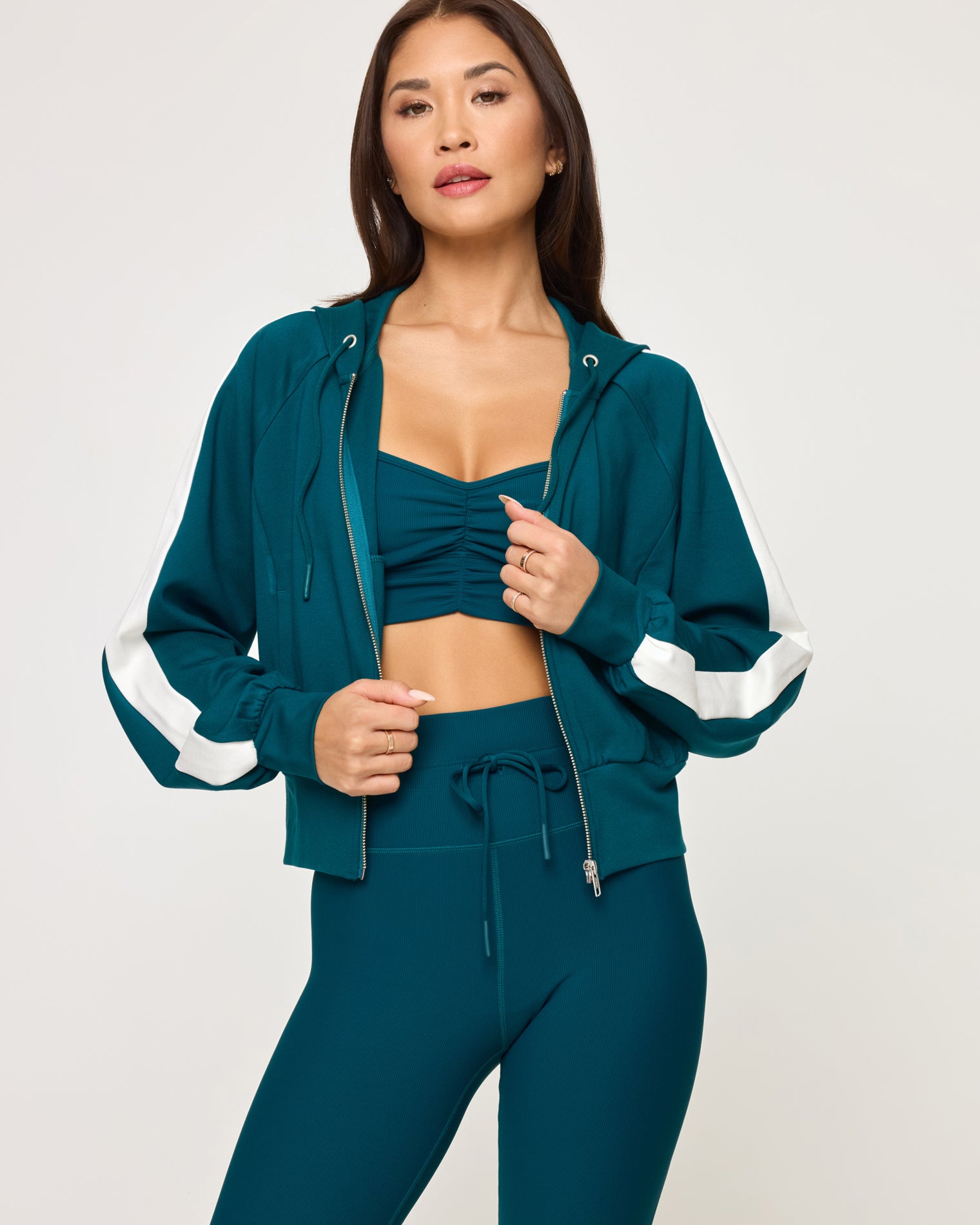 Back To Back Jacket - Deep Teal-Cream Close-up front view of model wearing the Back To Back Jacket in deep teal-cream, a zip-up track jacket with cream contrast panels and side stripe.