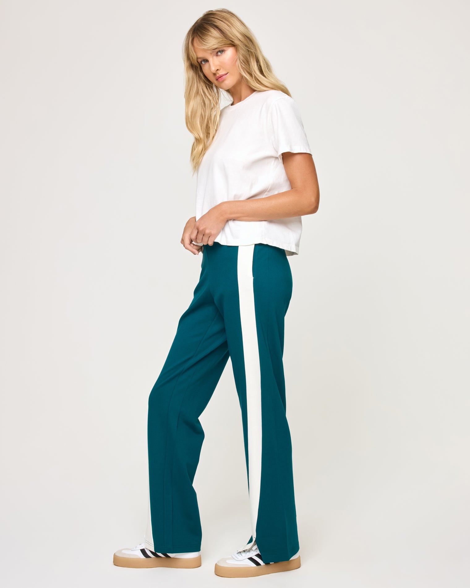Back To Back Pant - Deep Teal-Cream Side view of model wearing the Back To Back Pant in deep teal-cream showing the cream contrast side stripe, with matching Back To Back Jacket.