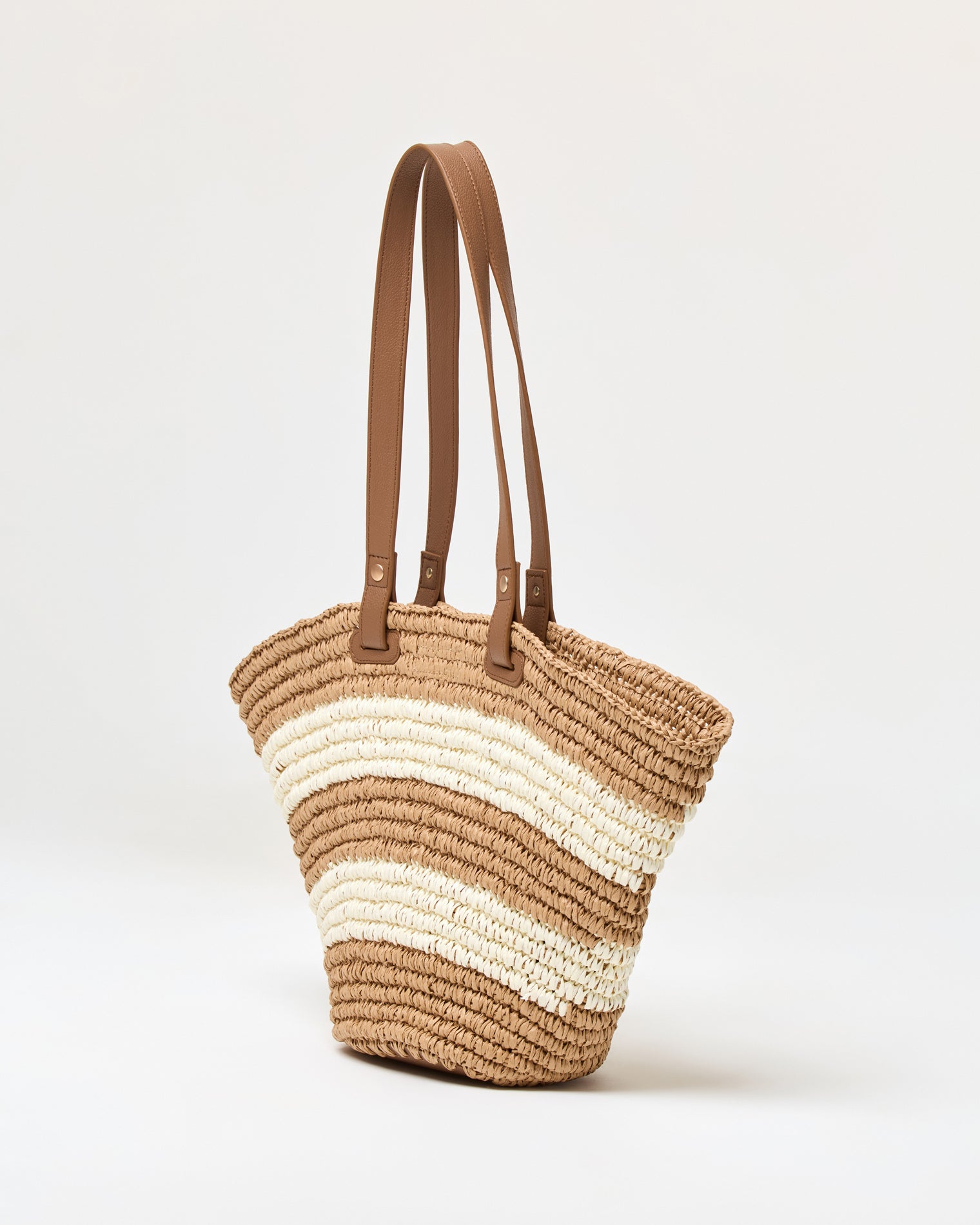 Yuli Tote - Natural Stripe Angled side view of the natural stripe Yuli Tote showing the woven texture and brown leather strap detail.