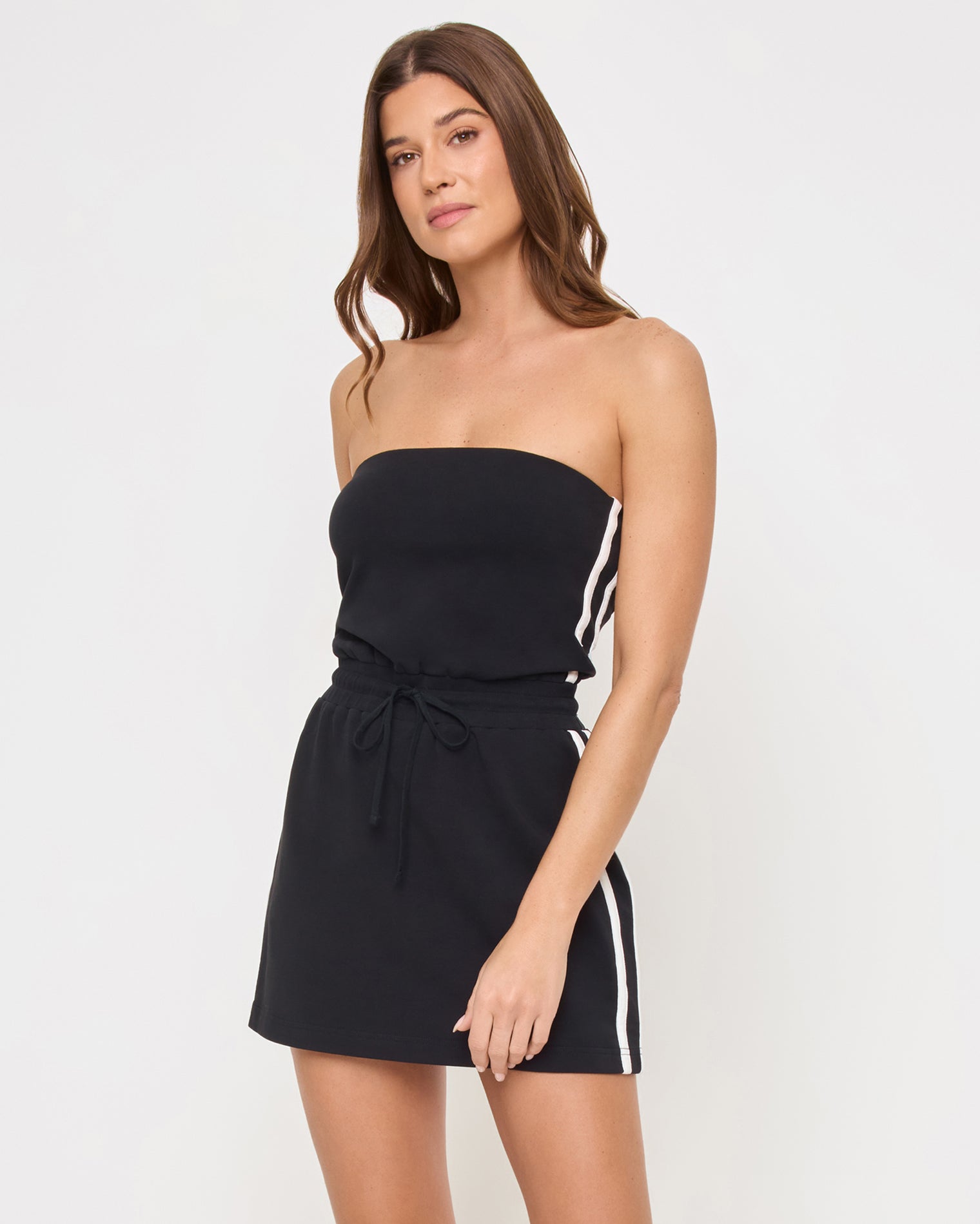 Decker Dress - Black-Cream Three-quarter view of the LSPACE Decker Dress in black-cream on a model against a light background, showing the cream trim detail of the active mini dress.