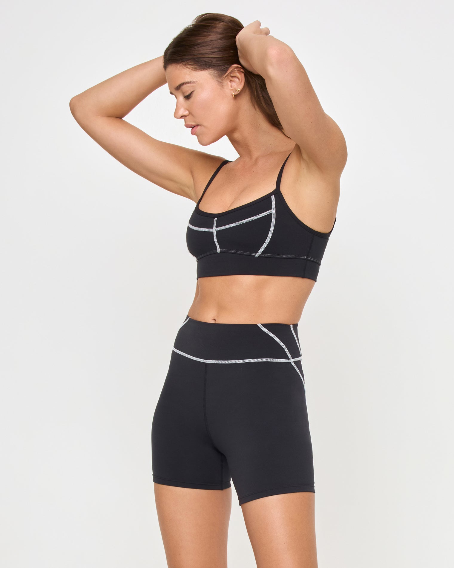 Star Power Shorts - Black Side view of the LSPACE Star Power Shorts in black on a model against a white background, paired with the matching black Eclipse Bra, showing the profile of the high-waist bike shorts.