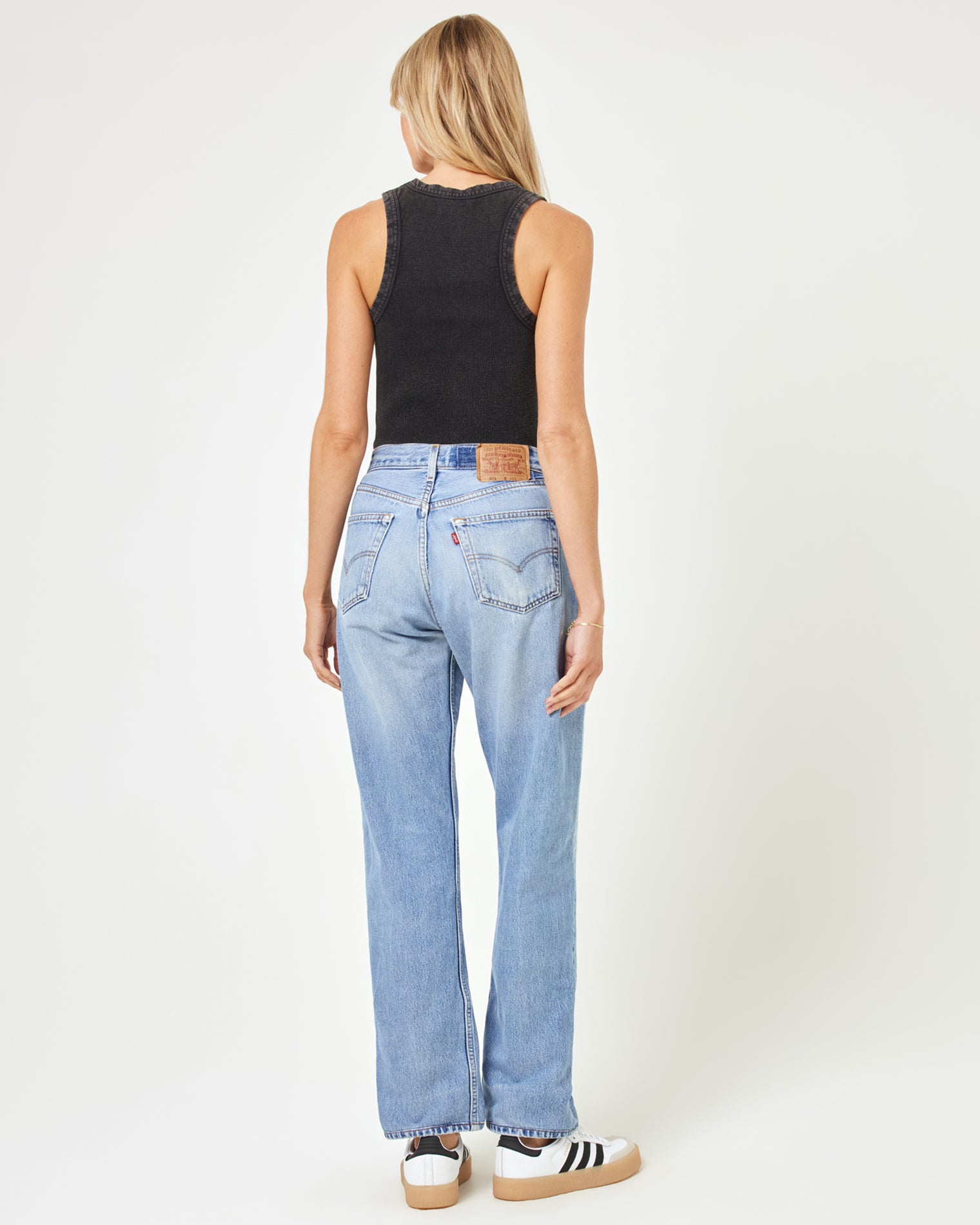 aligrace Brigette Baggy Denim Pant Back view of a model wearing the LSPACE aligrace Brigette Baggy Denim Pant in blue, styled with a black ribbed crop tank and sneakers.