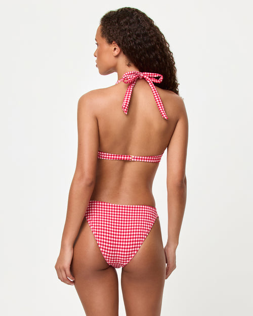 Back view of a model wearing the LSPACE lipstick red Isa bikini top and Dolce Bikini Bottom in a red gingham print with a cheeky cut.