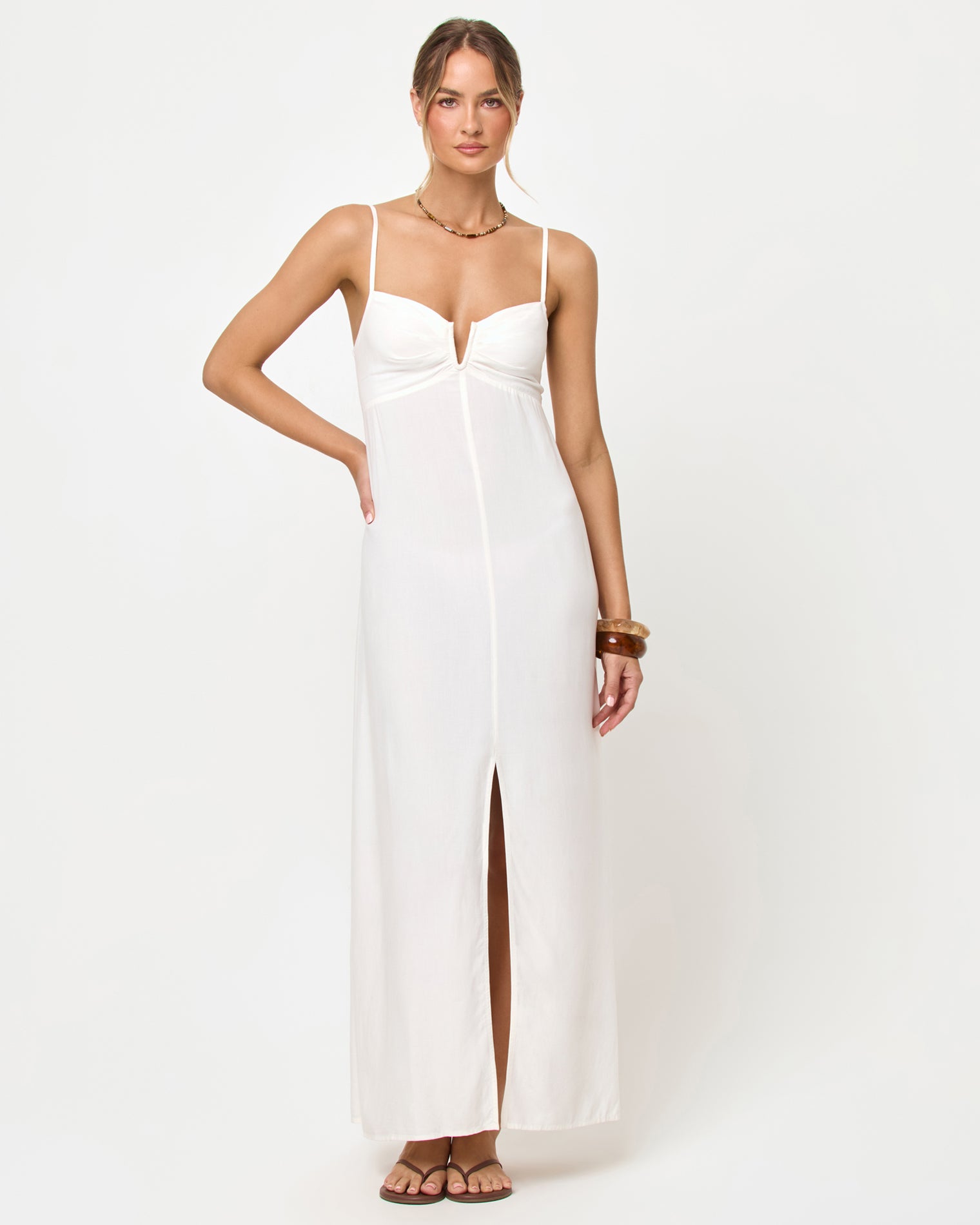 Chara Maxi Dress - Cream Cream | Badge:New Arrival_#B2AC88_#ffffff'
Front view of model wearing the LSPACE Chara Maxi Dress in cream, a floor-length sleeveless maxi dress with a deep V bustier-style neckline and front center slit.