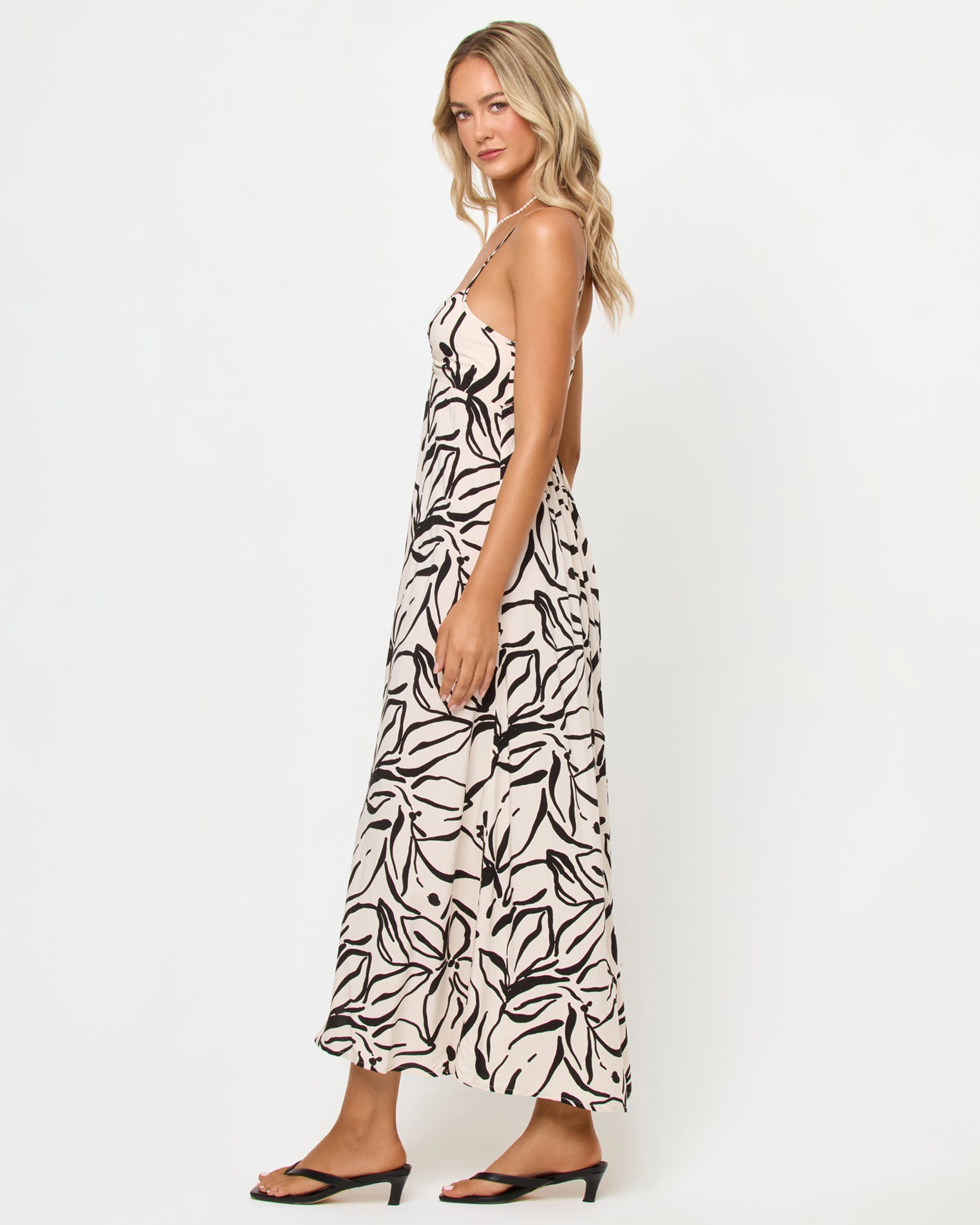 Chara Maxi Dress - Heavy Petal Side view of a model wearing the LSPACE Chara Maxi Dress in heavy petal, showing the full-length silhouette and open back detail, on a white studio background.