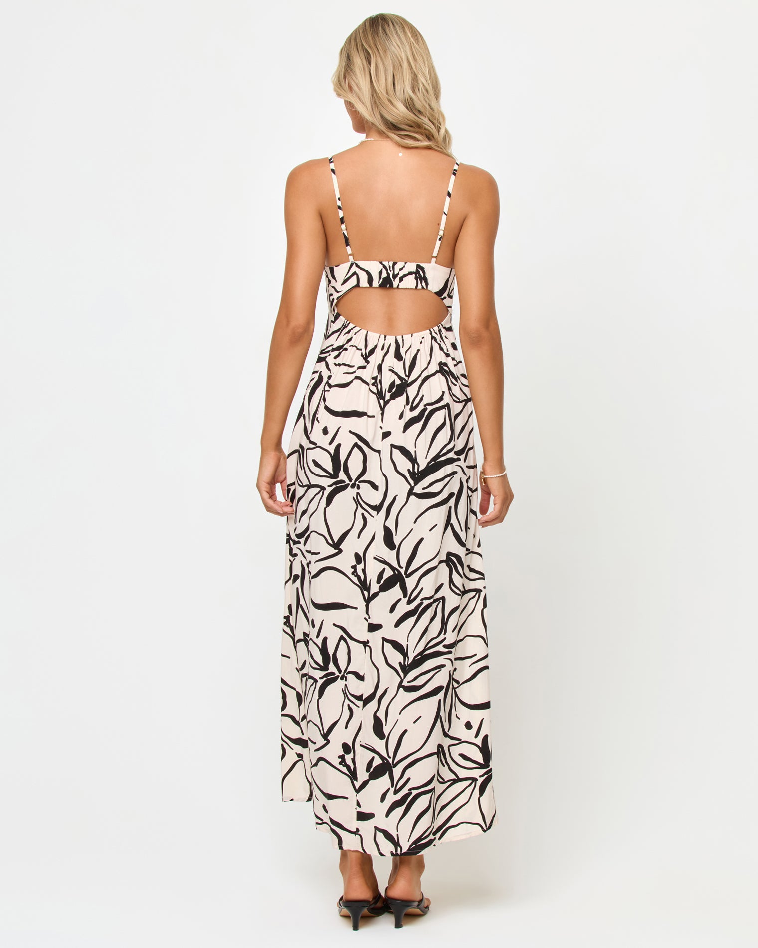 Chara Maxi Dress - Heavy Petal Back view of a model wearing the LSPACE Chara Maxi Dress in heavy petal, showing the open cut-out back panel and adjustable spaghetti straps, on a white studio background.