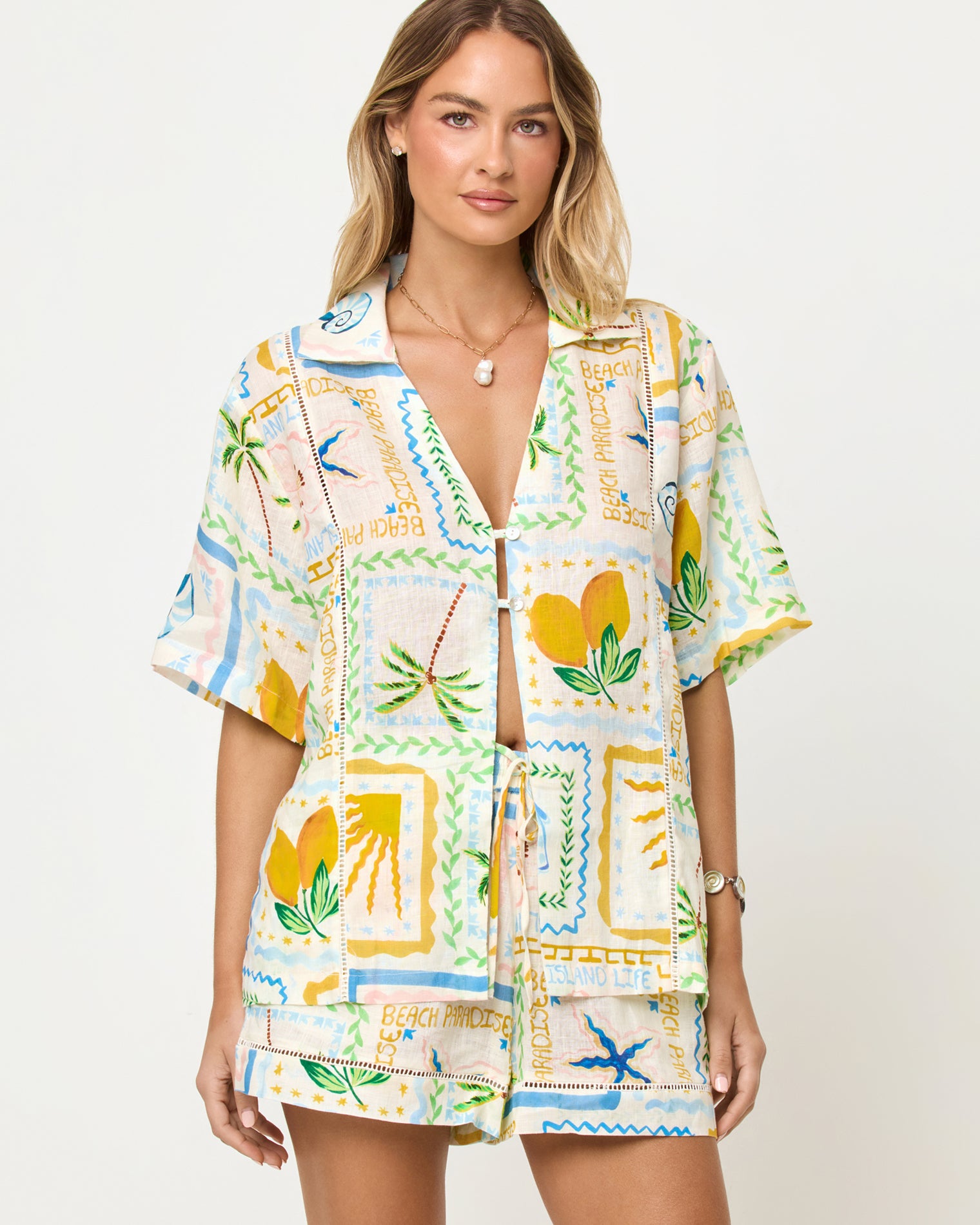 La Mer Shirt - Wish You Were Here LSPACE La Mer Short and Shirt in Wish You Were Here print, zoomed in front view on model styled with matching shorts.