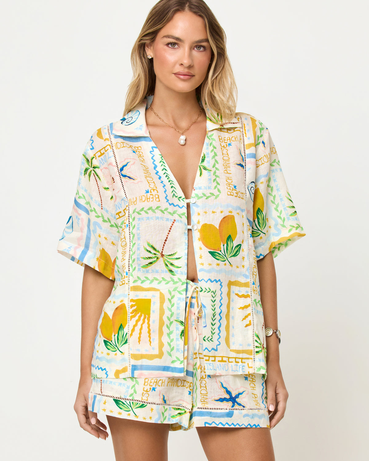 La Mer Shirt - Wish You Were Here LSPACE La Mer Short and Shirt in Wish You Were Here print, zoomed in front view on model styled with matching shorts.