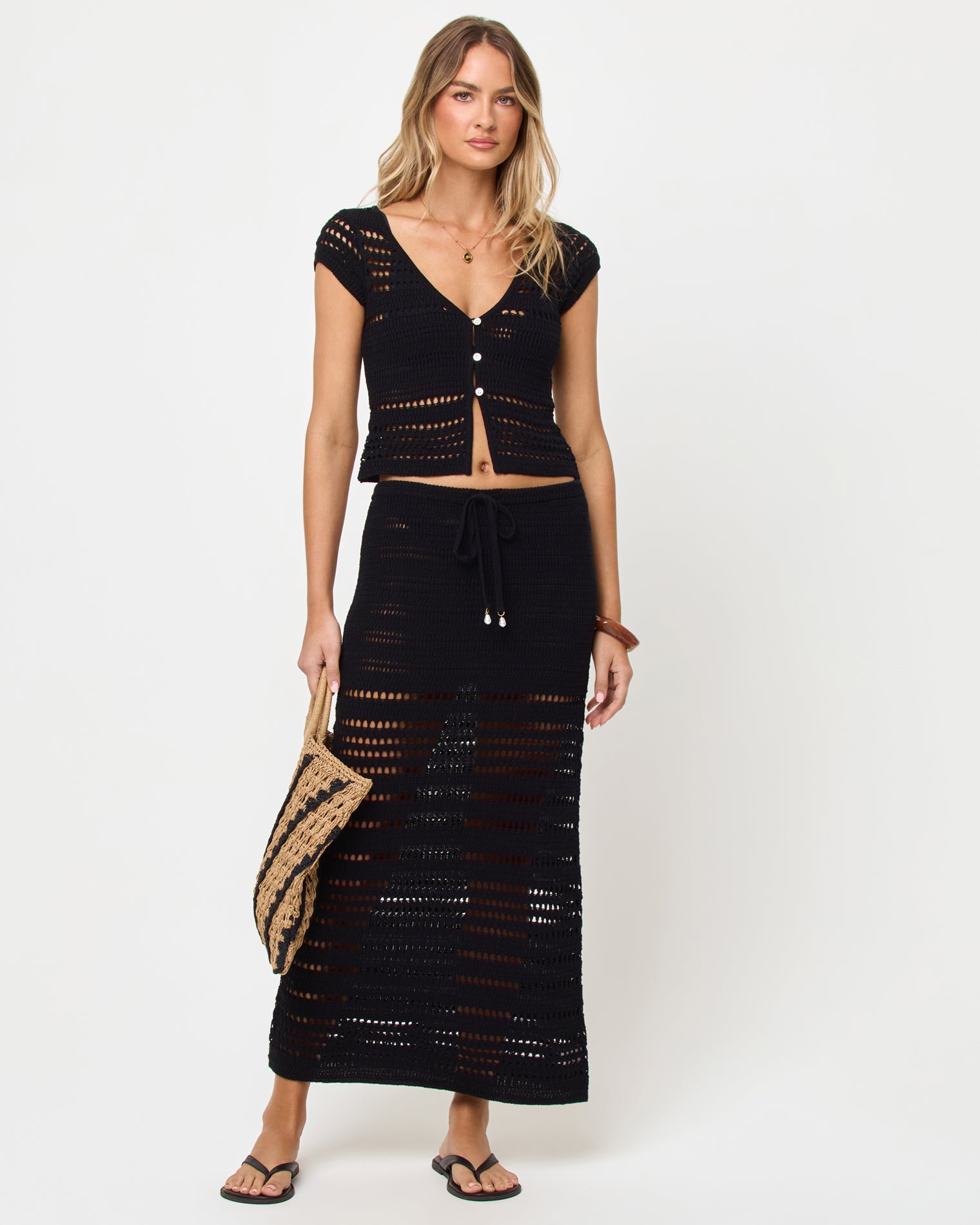 Tula Skirt - Black Black | Badge:New Arrival_#B2AC88_#ffffff'
Woman wearing a black crochet top and skirt set on a white background