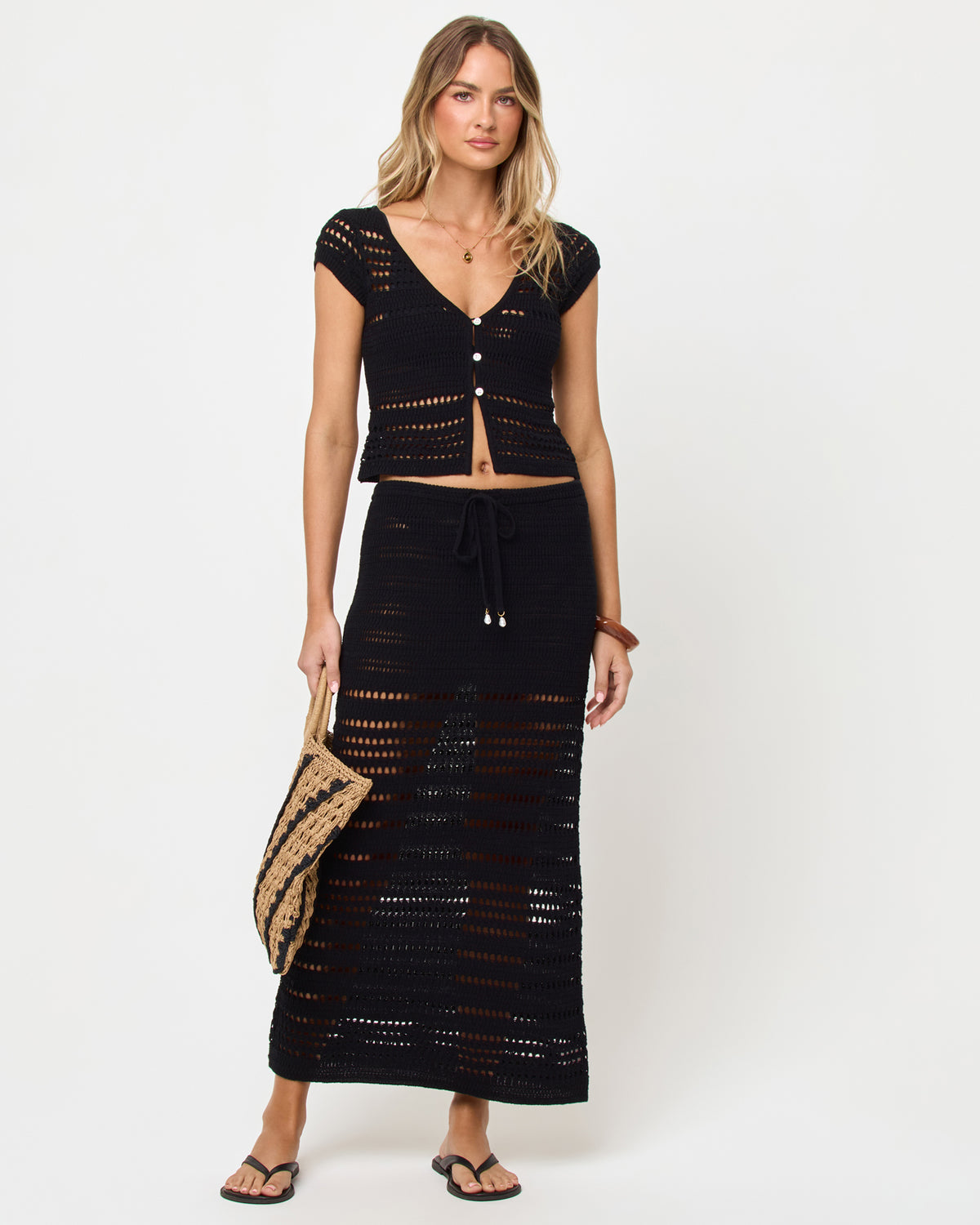 Tula Skirt - Black Black | Badge:New Arrival_#B2AC88_#ffffff'
Woman wearing a black crochet top and skirt set on a white background