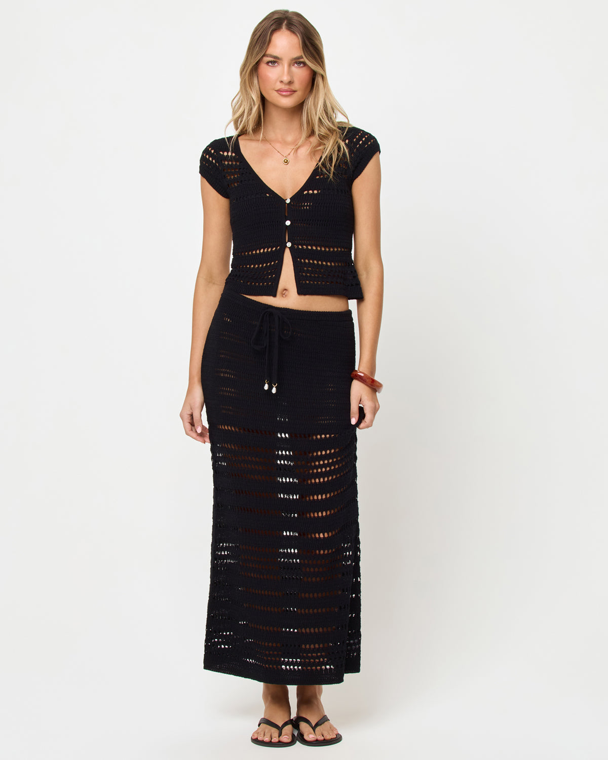 Tula Top - Black Woman wearing a black crochet top and skirt set on a white background