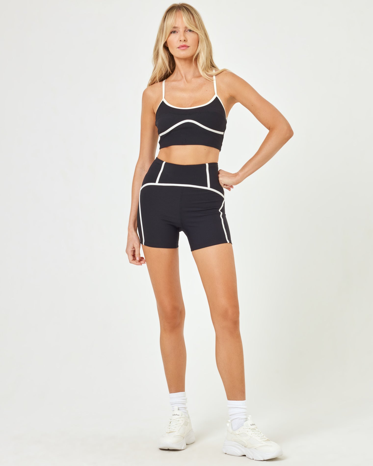 Revel Top - Black-Cream Front view of model wearing the Revel Top in black-cream with matching black-cream Revel Short and white sneakers.