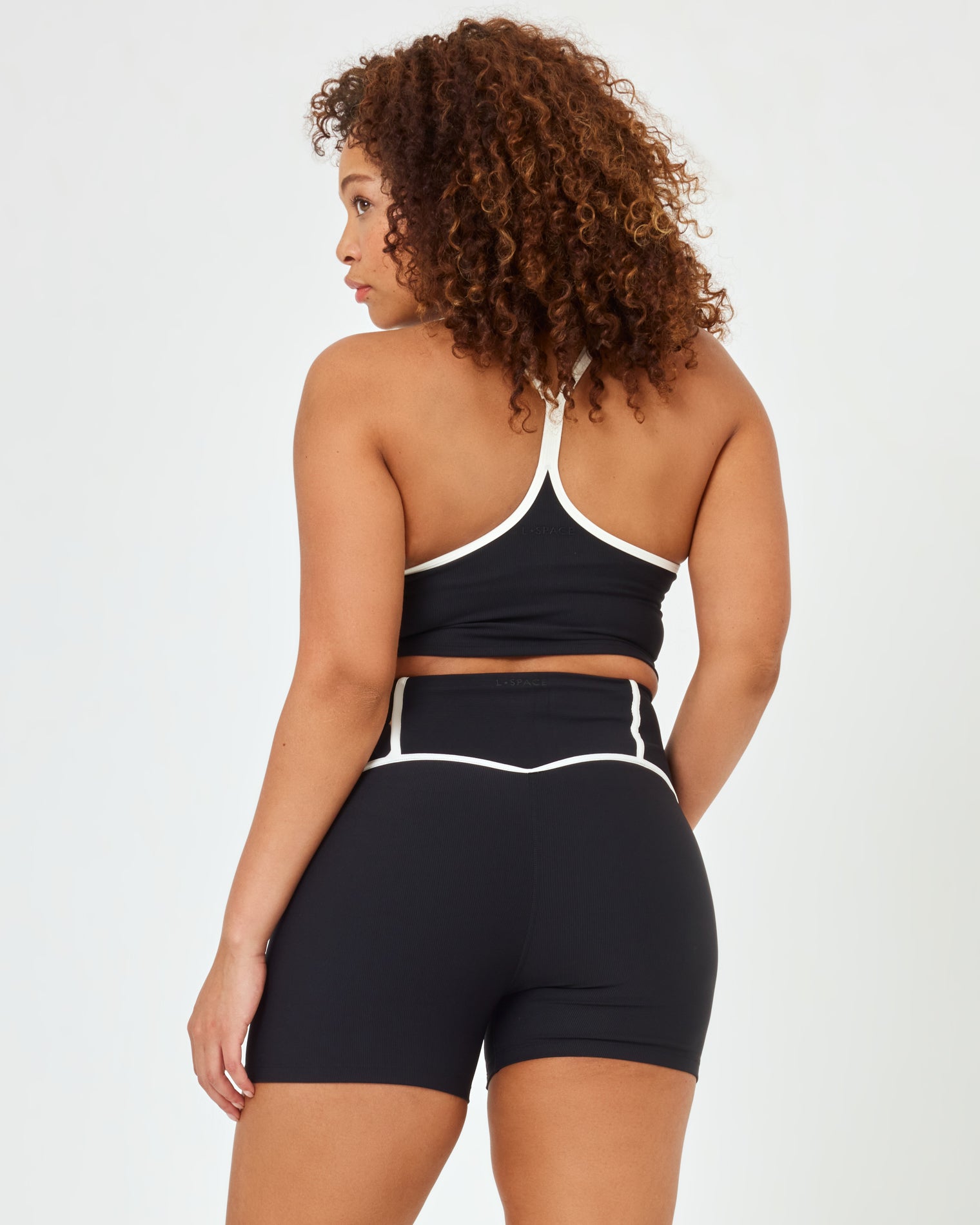 Revel Top - Black-Cream Back view of plus size model wearing the Revel Top in black-cream showing the crossback strap detail with cream piping, with matching black-cream Revel Short.