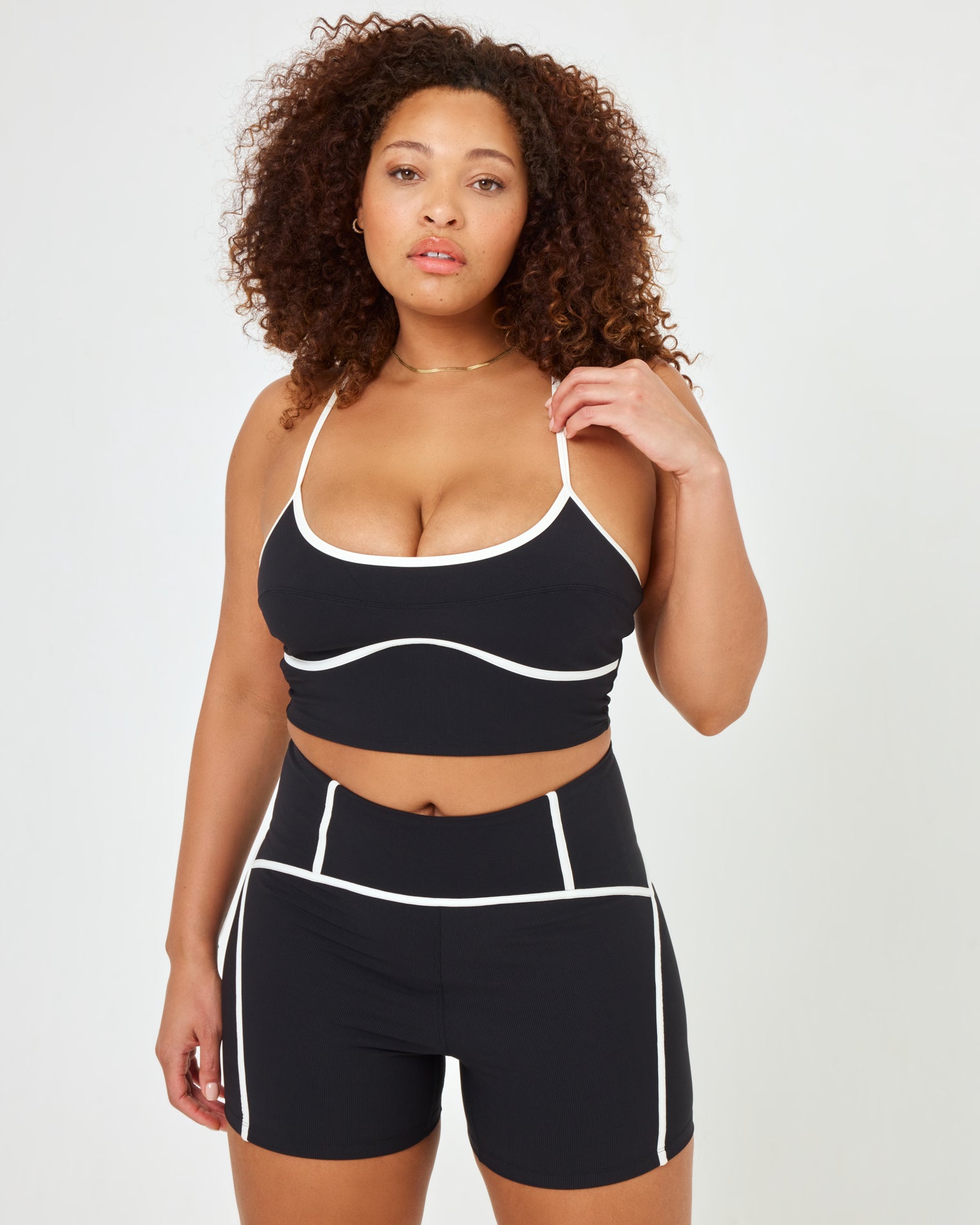 Revel Top - Black-Cream Close-up front view of model wearing the Revel Top in XL showing the scoop neckline and cream piping, with matching black-cream Revel Short.