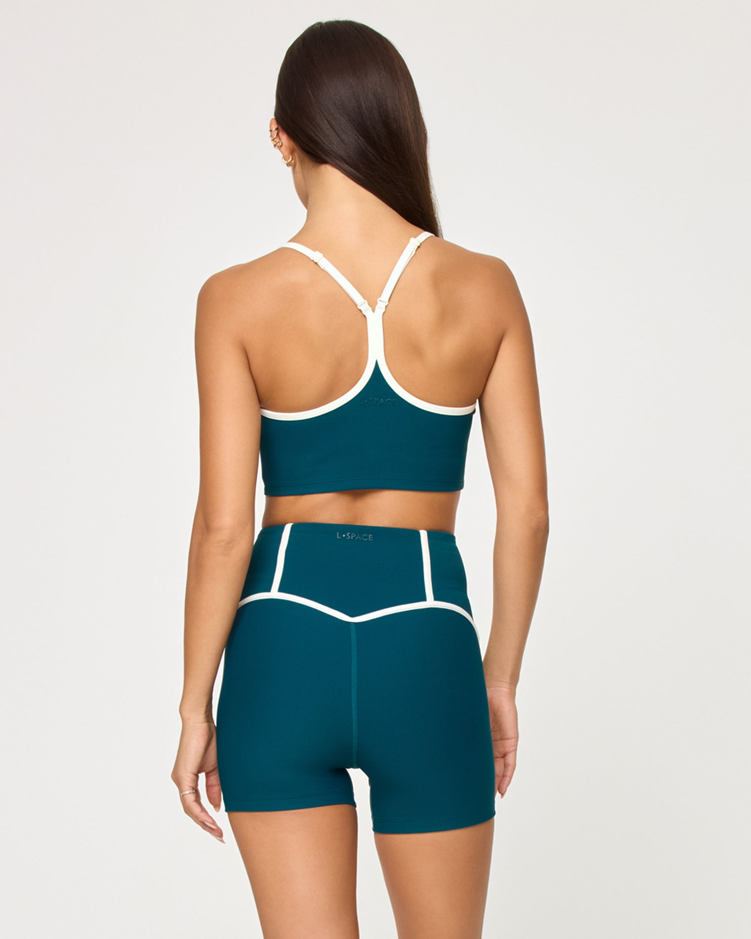 Revel Top - Deep Teal-Cream Back view of model wearing the Revel Top in deep teal-cream showing the crossback strap detail with cream piping, with matching deep teal-cream Revel Short.