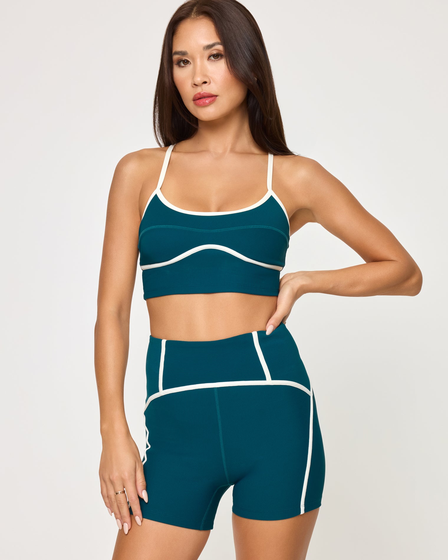 Revel Top - Deep Teal-Cream Close-up front view of model wearing the Revel Top in deep teal-cream showing the scoop neckline and cream piping detail, with matching deep teal-cream Revel Short, hand on hip.