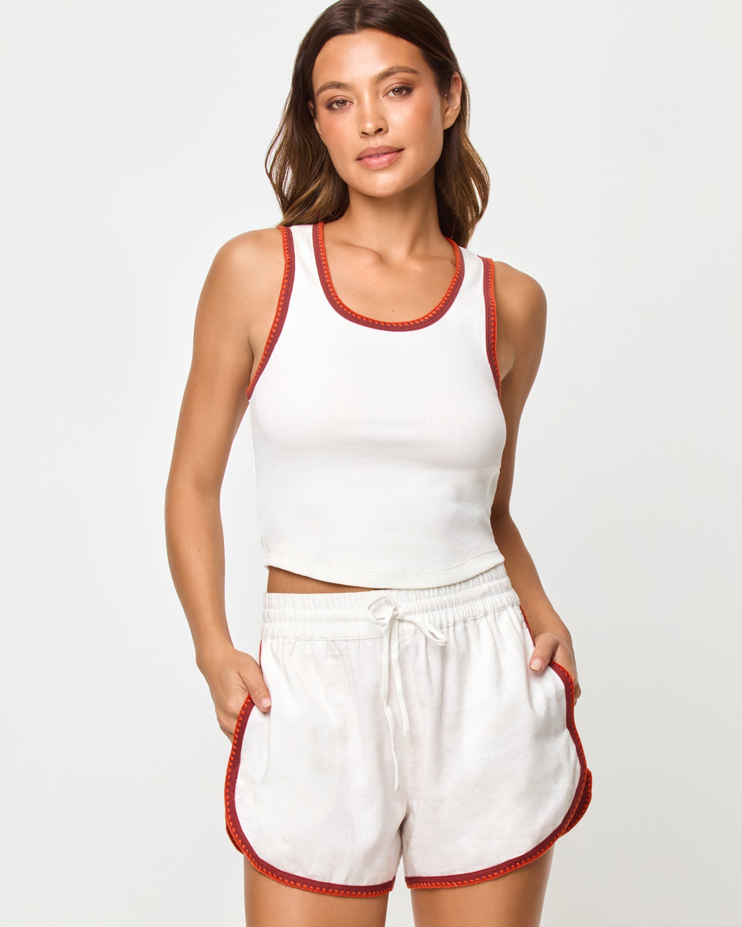 Rune Short - Cream Fig Poppy Cream Fig Poppy | Badge:New Arrival_#B2AC88_#ffffff'
Front studio torso view of the Ash Tank and Rune Short in Cream Fig Poppy, a cream ribbed scoop-neck crop tank with rust and terracotta crochet trim at the neckline and straps paired with matching cream runner shorts with the same crochet trim at the waistband and hem.
