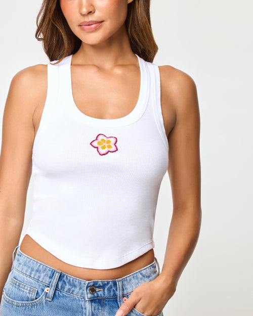 LSPACE Ash tank in Plumeria, close-up detail view of embroidered plumeria graphic on model.