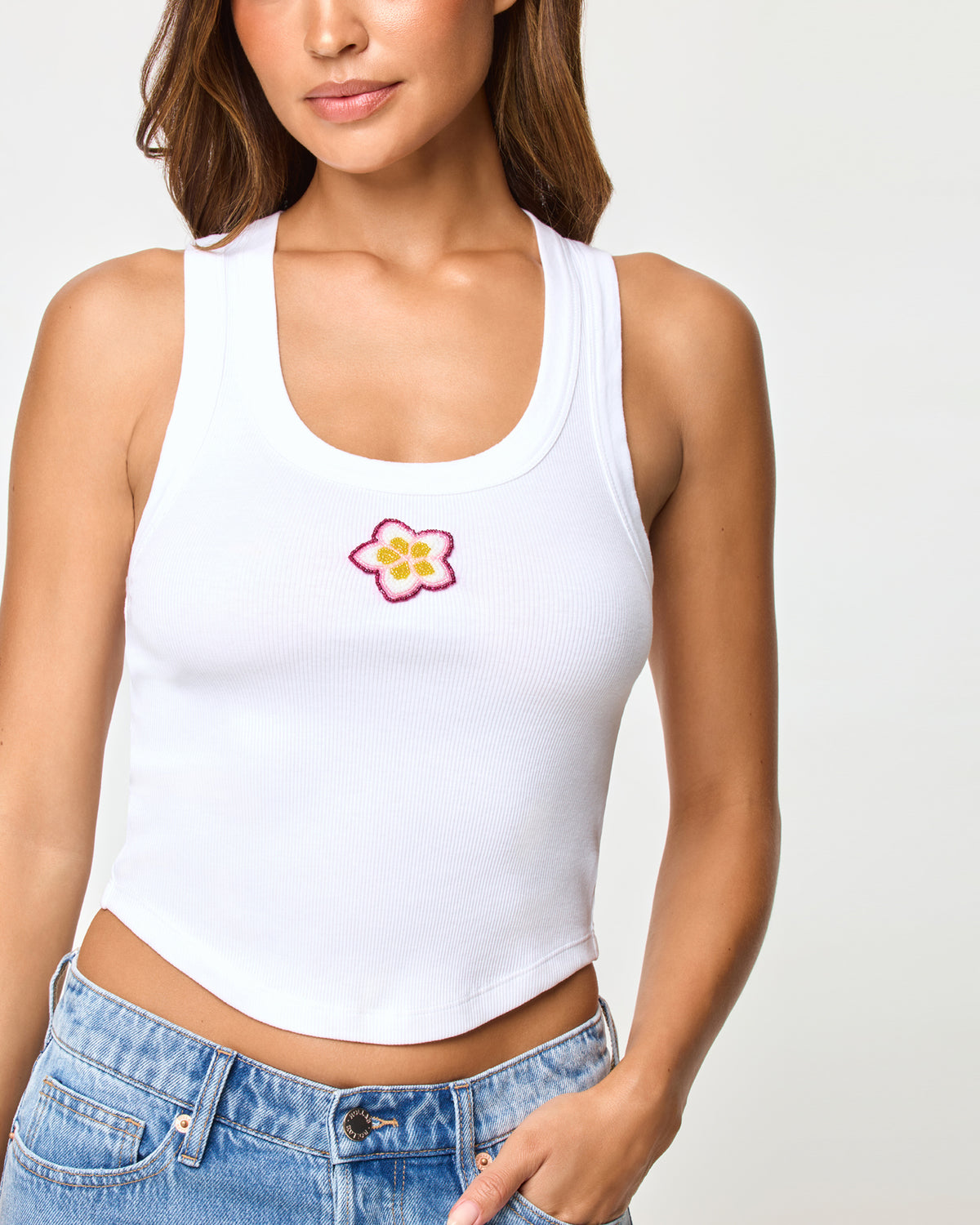 Ash Tank - Plumeria LSPACE Ash tank in Plumeria, close-up detail view of embroidered plumeria graphic on model.