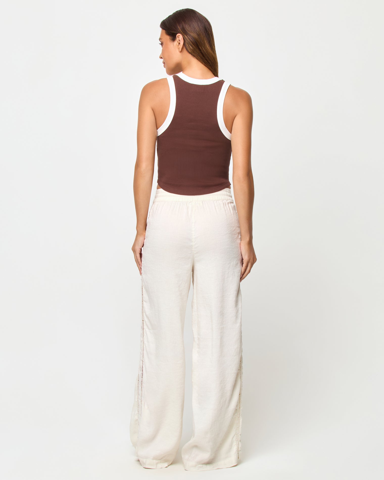 Ash Tank - Espresso Cream Back view of a model wearing the LSPACE Ash Tank in espresso-cream, showing the racerback detail with cream contrast trim against the espresso brown body, styled with cream wide-leg drawstring pants.