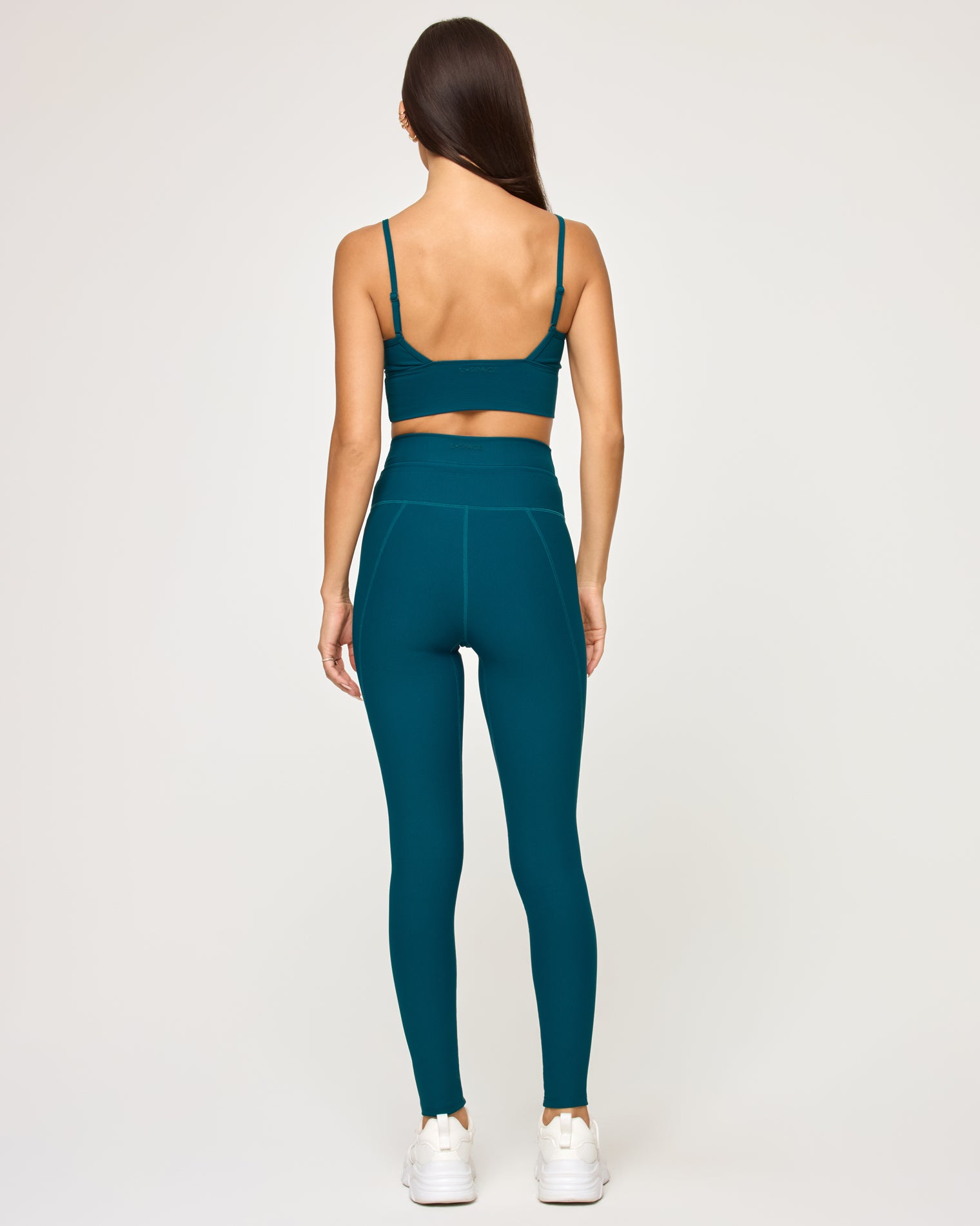 Soren Top - Deep Teal Back view of model wearing the Soren Top in deep teal showing the open crossback spaghetti strap detail, with matching deep teal Turner Legging and white sneakers.