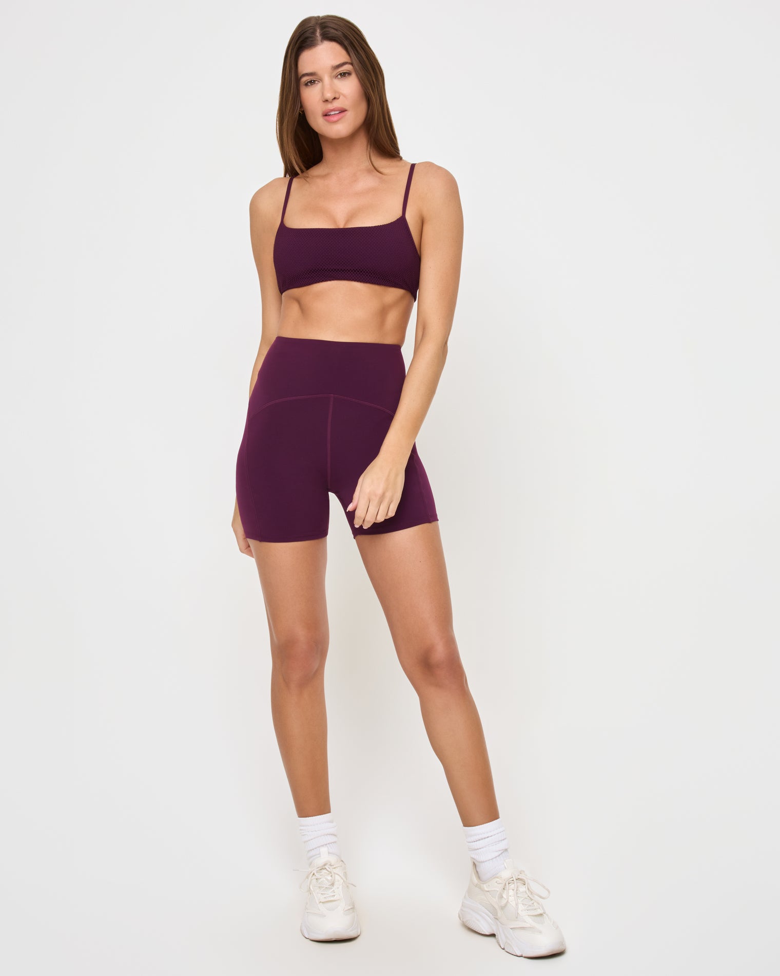 En Pointe Short - Plum Front view of the LSPACE En Pointe Short in plum on a model against a white background, showing the high-waist active shorts, paired with the matching plum Stride Bra.