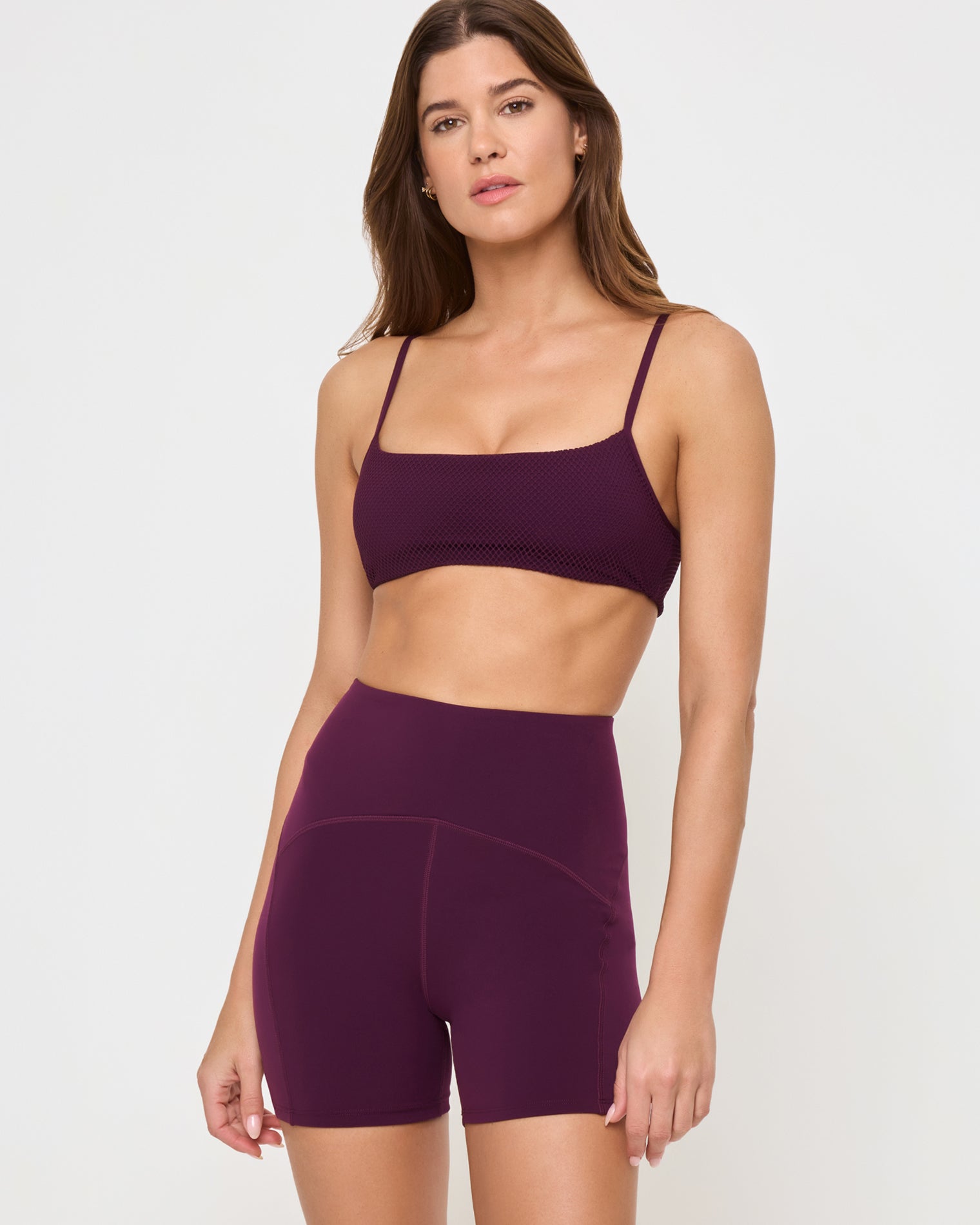 En Pointe Short - Plum Close-up front view from the knees up of the LSPACE En Pointe Short in plum on a model against a white background, highlighting the waistband and silhouette of the high-waist active shorts.