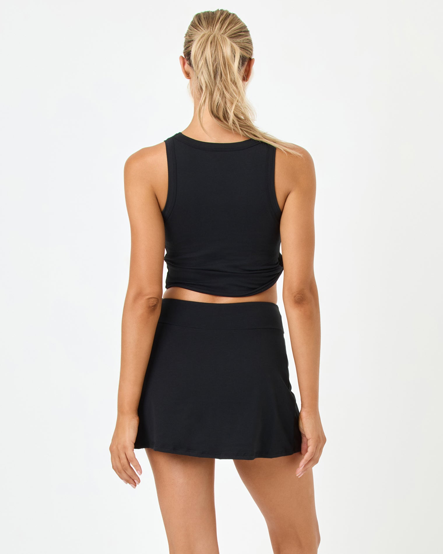 Romeo Skort - Black Back studio view of the Romeo Top and Skort in black, a black racerback crop tank paired with a black A-line wrap skort.