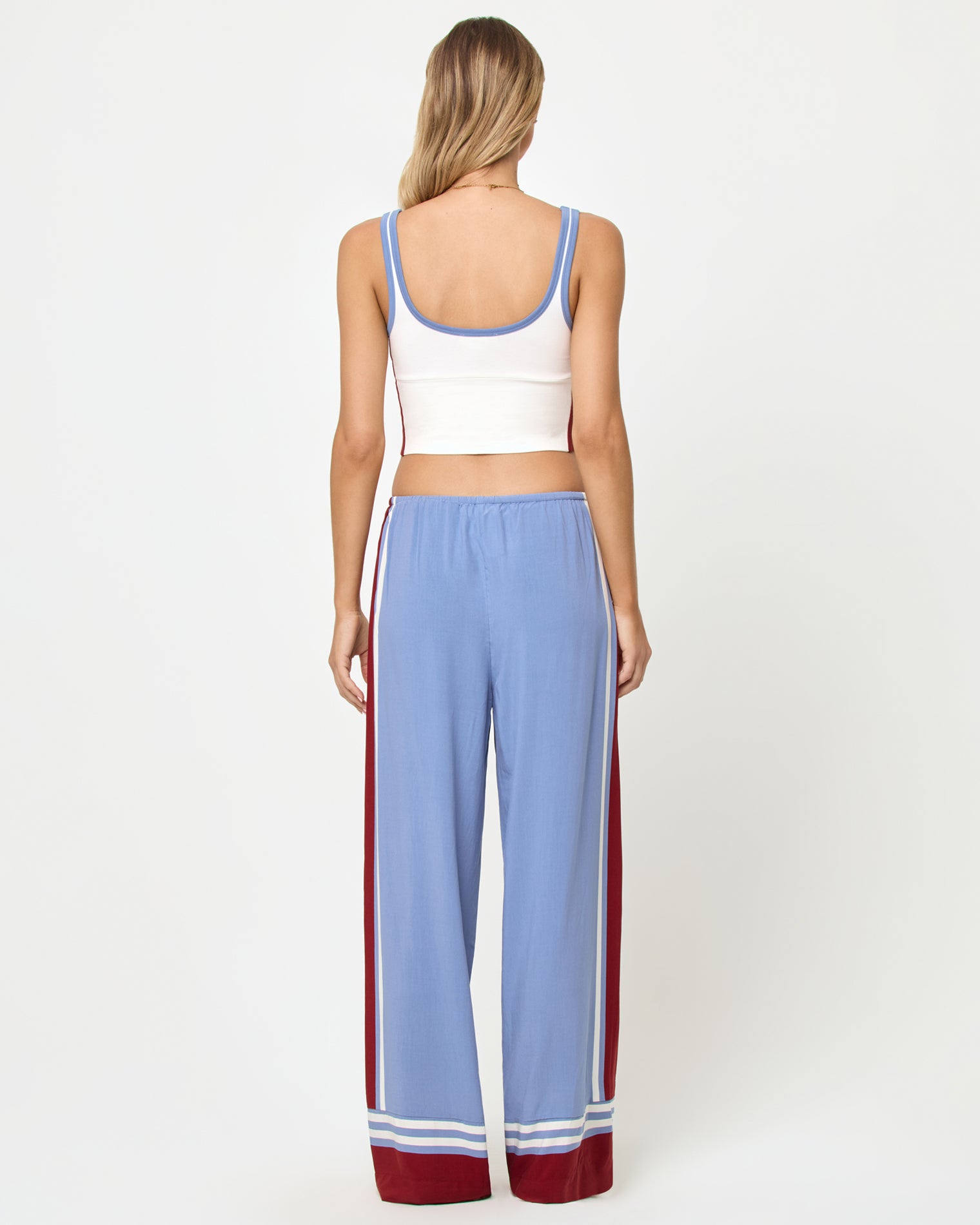 Reset Tank - Cream Chambray Fig Back full-length studio view of the Reset Tank in Cream-Chambray-Fig, a cream ribbed scoop-neck crop cami with chambray blue strap trim and burgundy color-block side panels, styled with chambray blue wide-leg stripe pants with burgundy side stripes and stripe trim at the ankle hem.