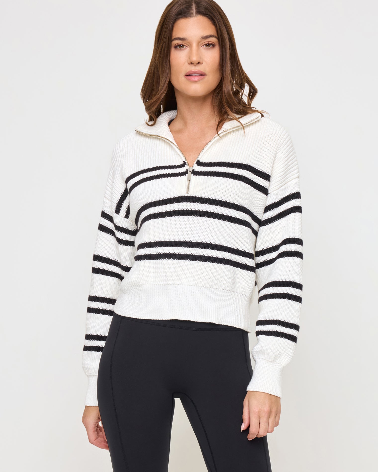 Ultra Stripe Sweater - Black White Close-up front view of the LSPACE Ultra Stripe Sweater in black-white on a model, showing the bold black and white horizontal stripe pattern and half-zip neckline detail.