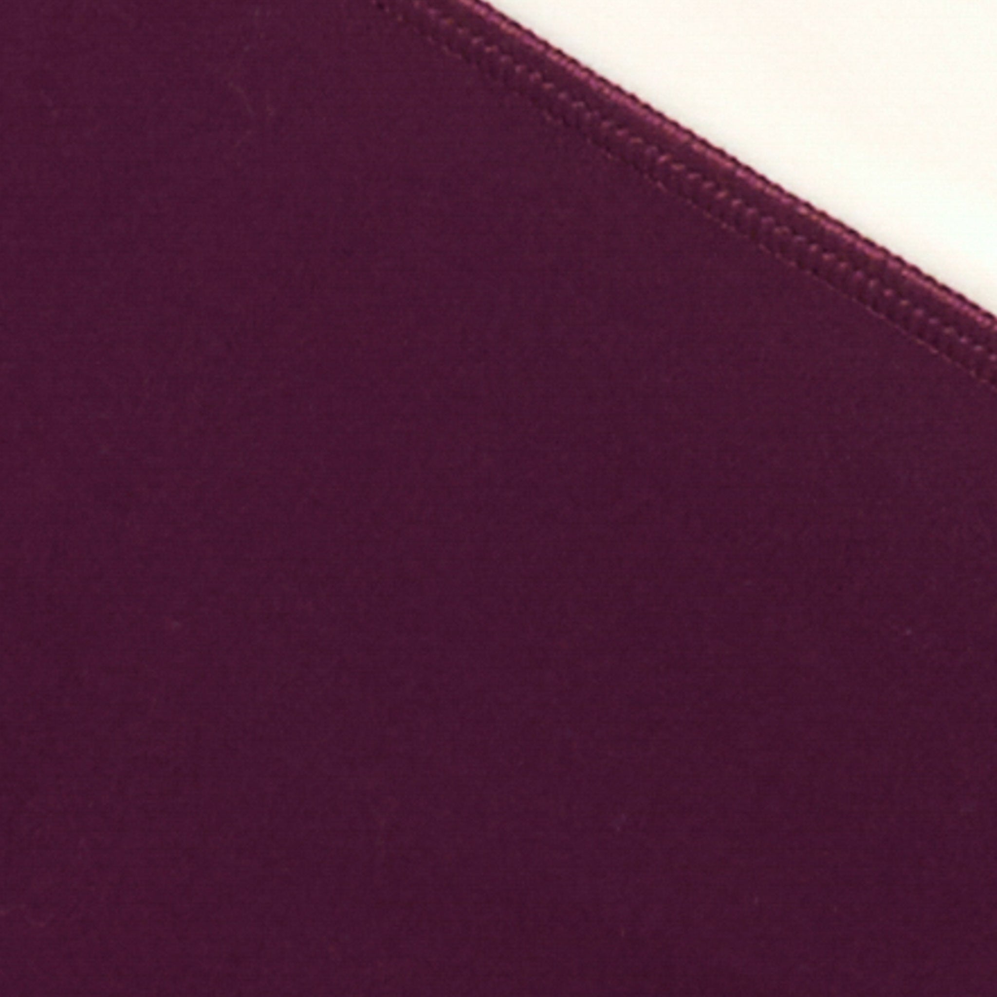 Unmatched Legging - Plum-Cream Fabric swatch for the LSPACE Unmatched Legging in plum-cream, showing the deep plum fabric color and cream contrast edge seam detail.