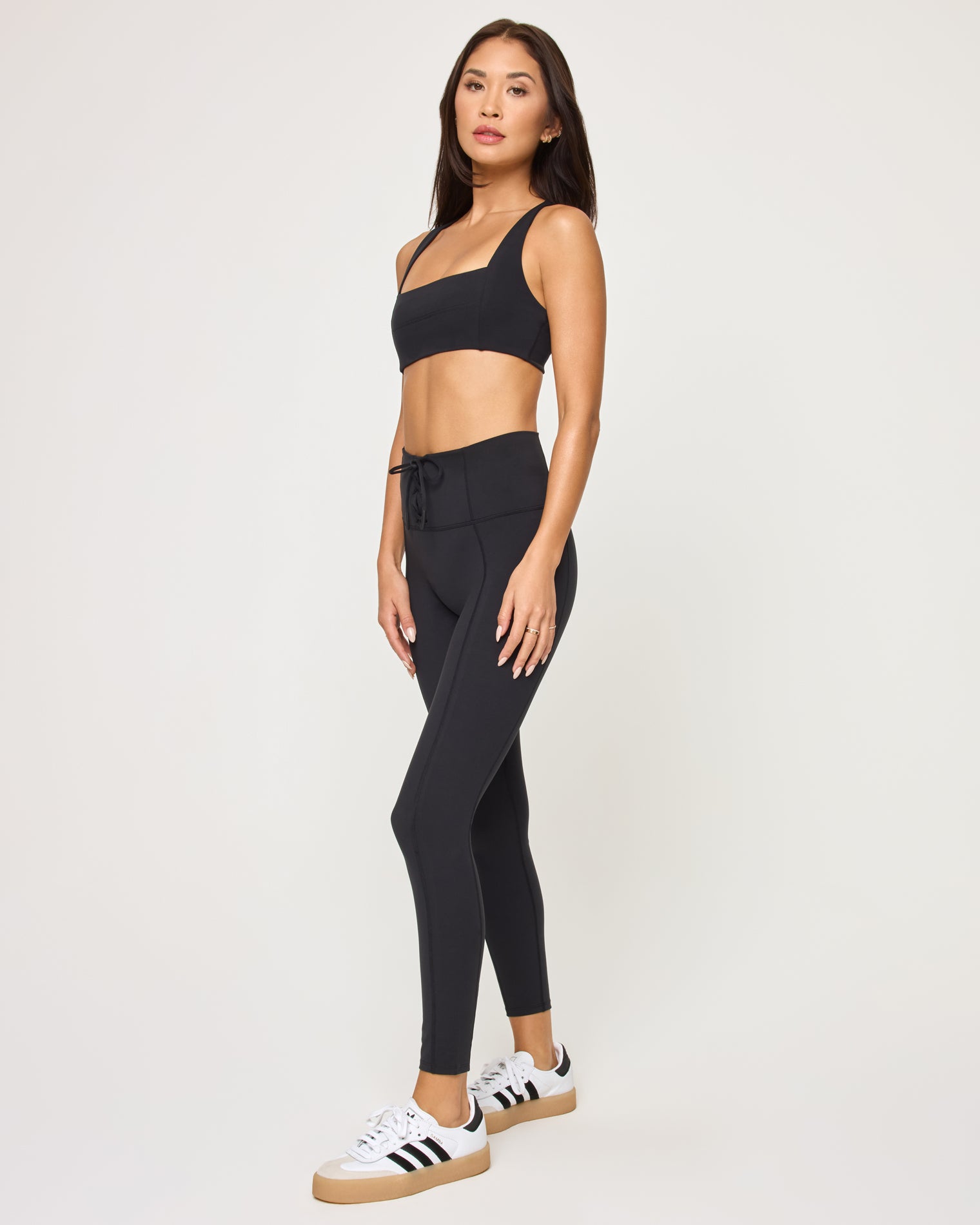 Contender Legging - Black Side view of model wearing the Contender Legging in black with matching black sports bra.