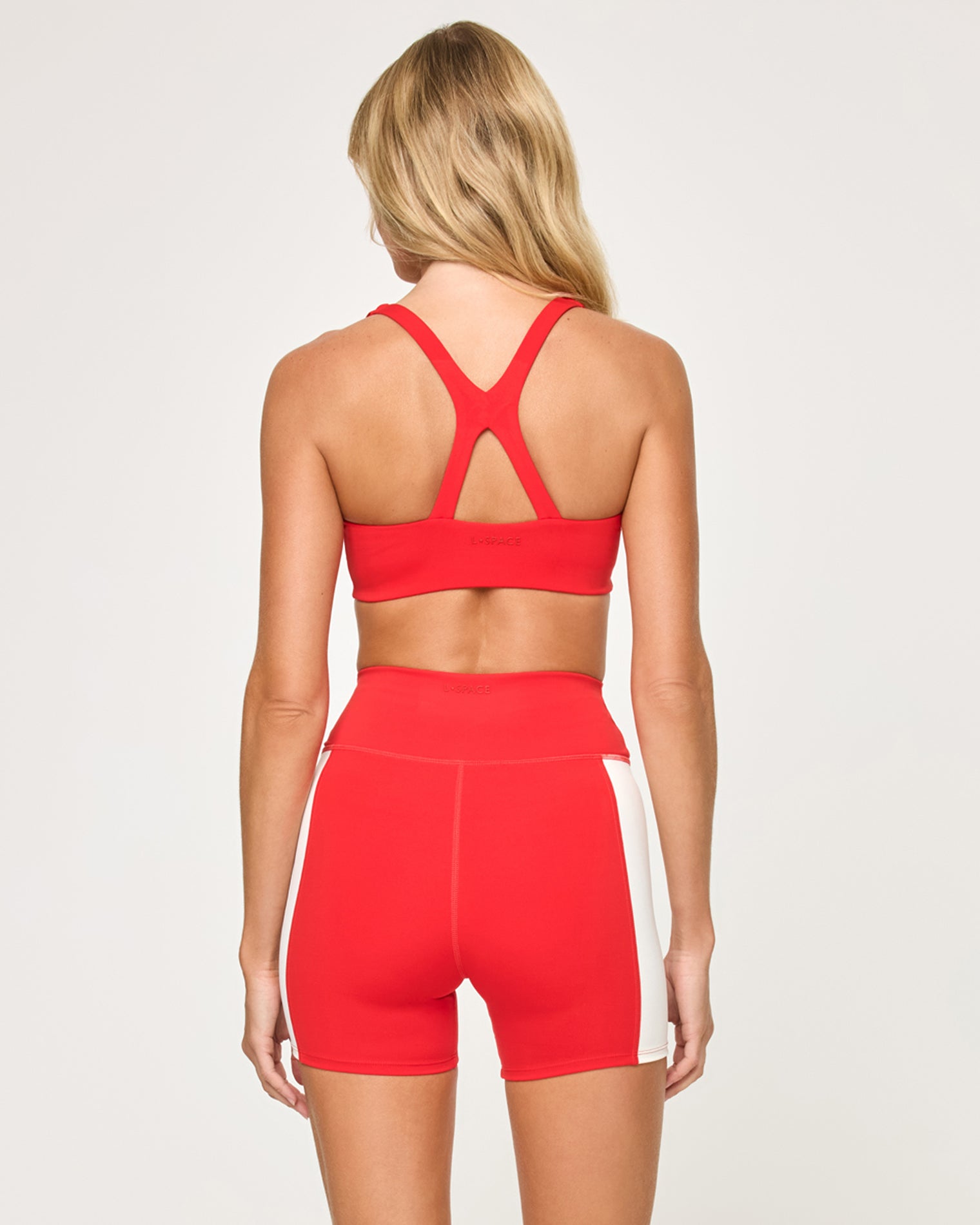 Uppercut Short - Flame-Cream Back view of the LSPACE Uppercut Short in flame-cream on a model against a white background, showing the back of the high-rise active shorts with cream trim, paired with the matching flame-cream sports bra.