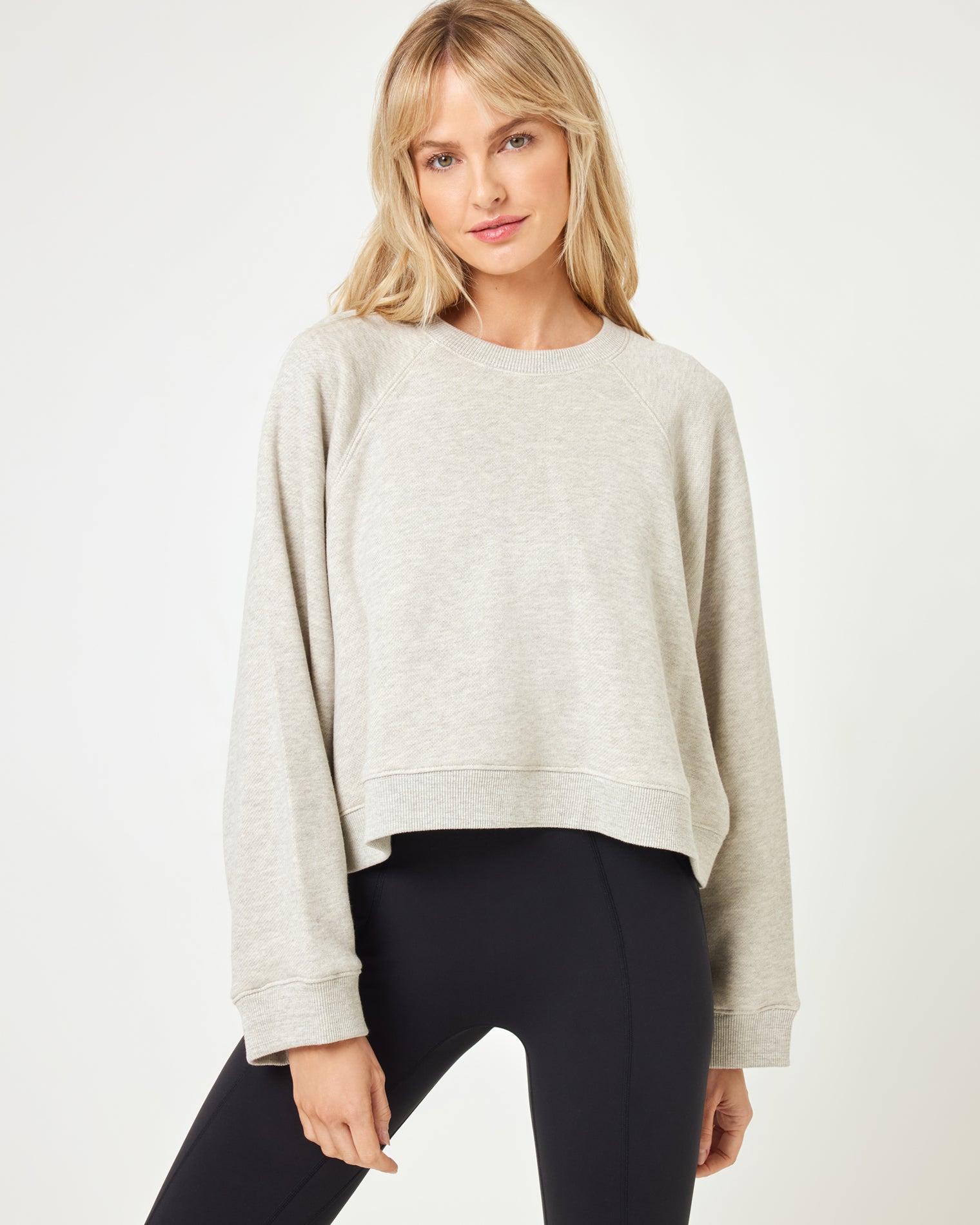 Vincent Pullover - Heather Grey Close-up front view of model wearing the Vincent Pullover in heather grey, a cropped crewneck sweatshirt, with black leggings.