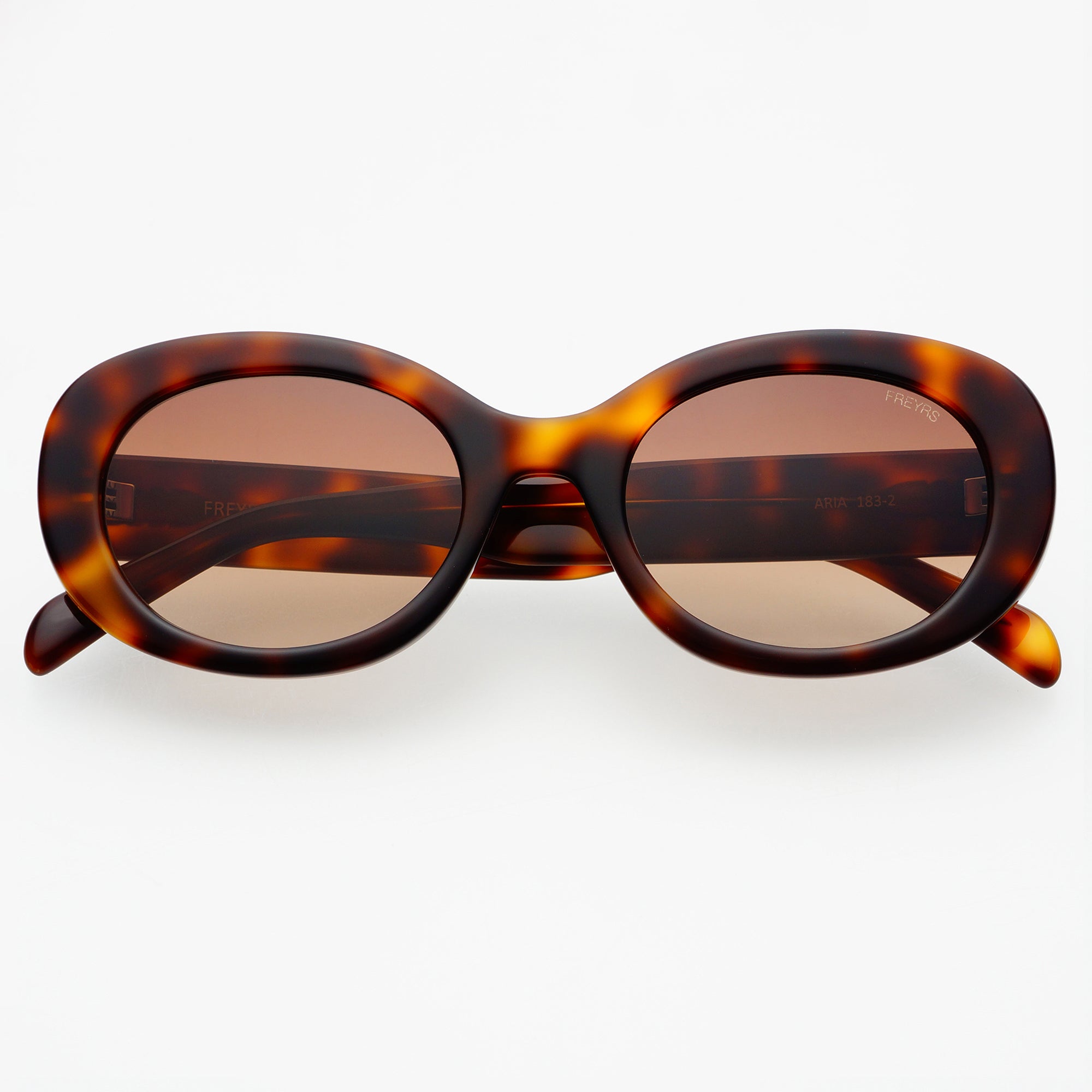 Freyrs Aria Sunglasses - Brown Off-model image of the Freyrs Aria Sunglasses in brown, folded flat with chunky oval brown tortoise acetate frame and brown gradient lenses.