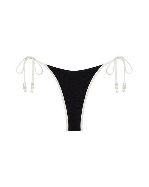 Off-model front view of the LSPACE Black-Cream Lucia Bikini Bottom showing the black fabric with cream tie-sides and pearl bead details.