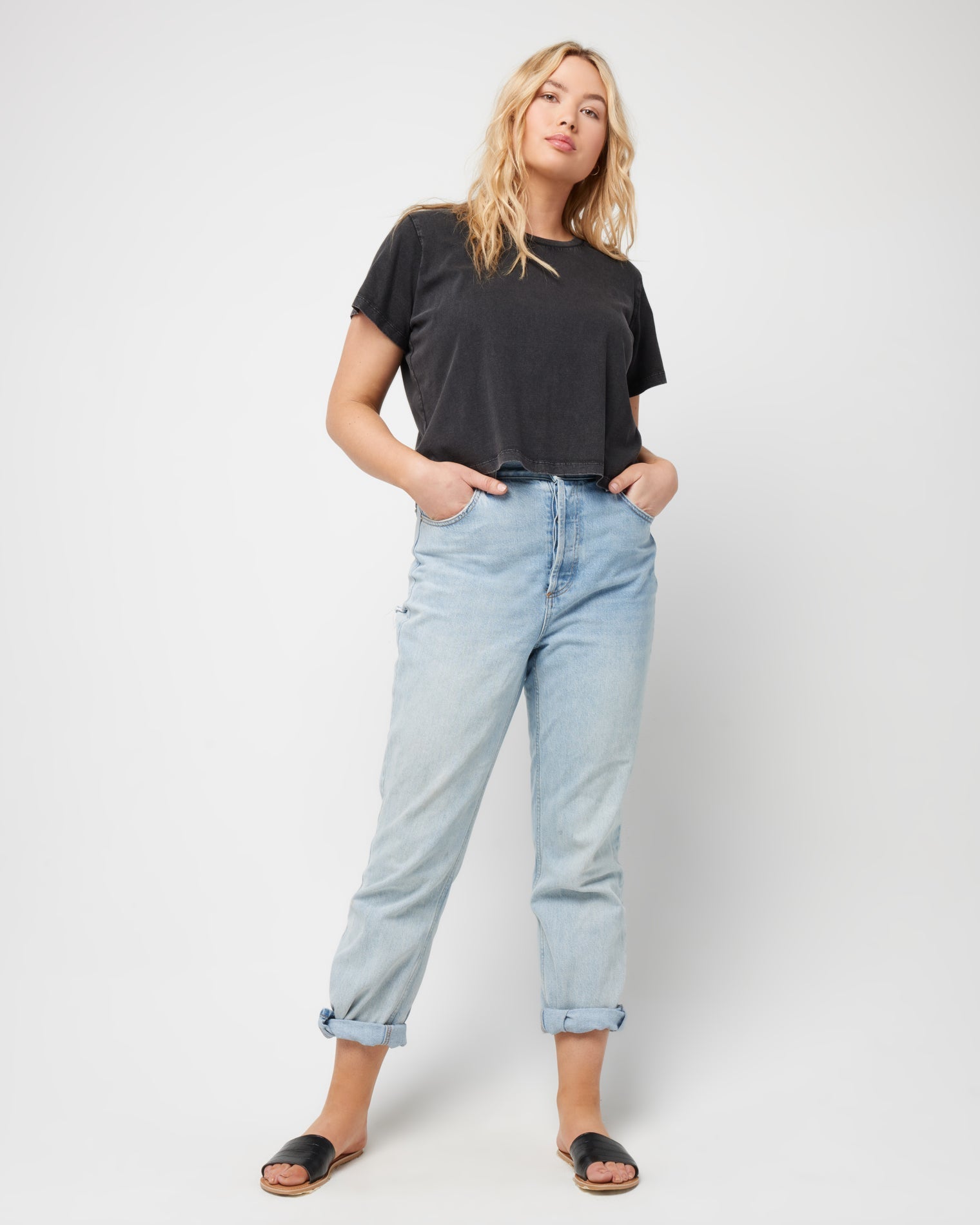 All Day Top - Black Full body front view of a model wearing the LSPACE All Day Top in black, styled with rolled-up light wash jeans and sandals.