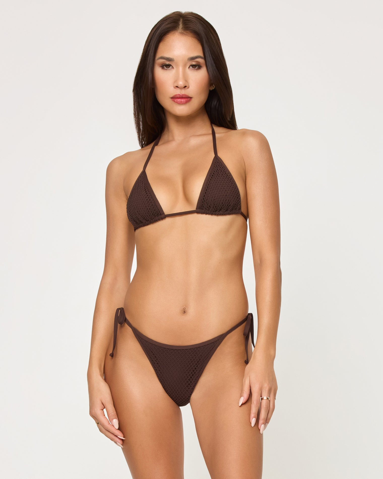 Aspen Bikini Top - Espresso Front view of a model wearing the LSPACE espresso Aspen Bikini Top, a textured triangle halter style with adjustable neck ties, paired with a matching espresso textured Levy Bikini Bottom with side-tie closure.