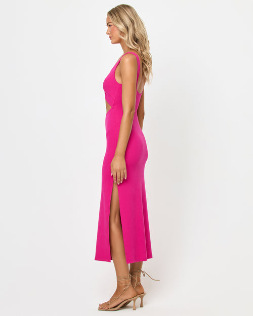 Side view of a model wearing the LSPACE Camille Dress in Bougainvillea, showing the fitted ribbed knit silhouette, side cutout detail, and side slit, on a neutral studio background.