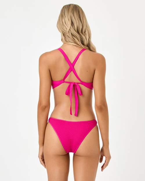 Back view of a model wearing the LSPACE bougainvillea Tyla Bikini Top and Suzi Bikini Bottom.