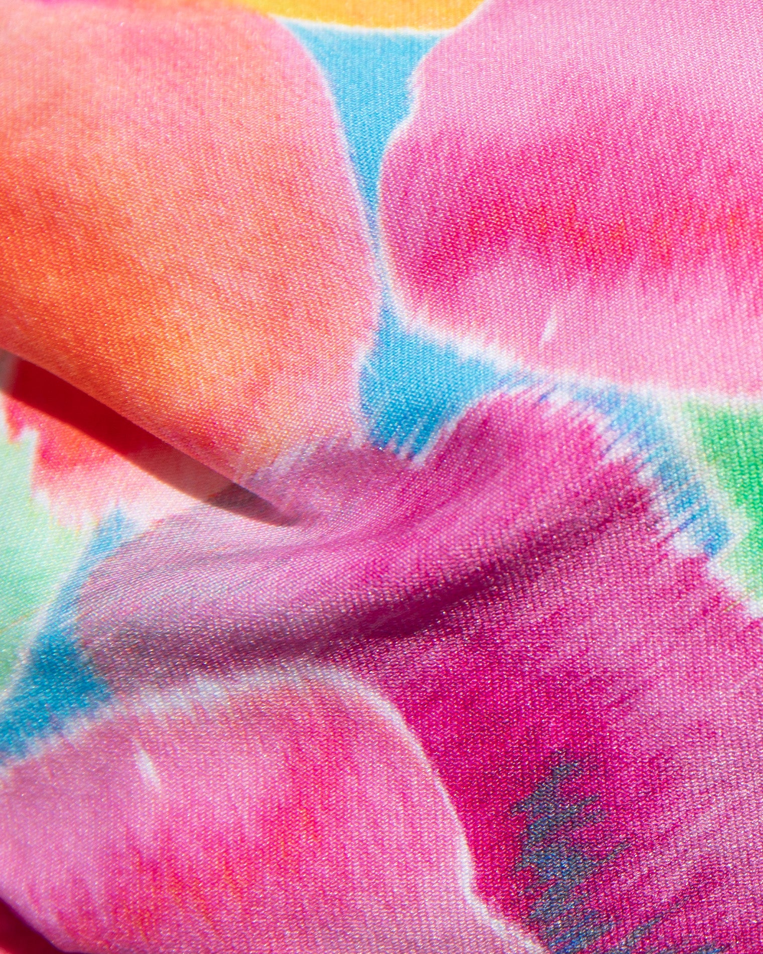 Close-up of colorful fabric with pink, orange, and blue hues.