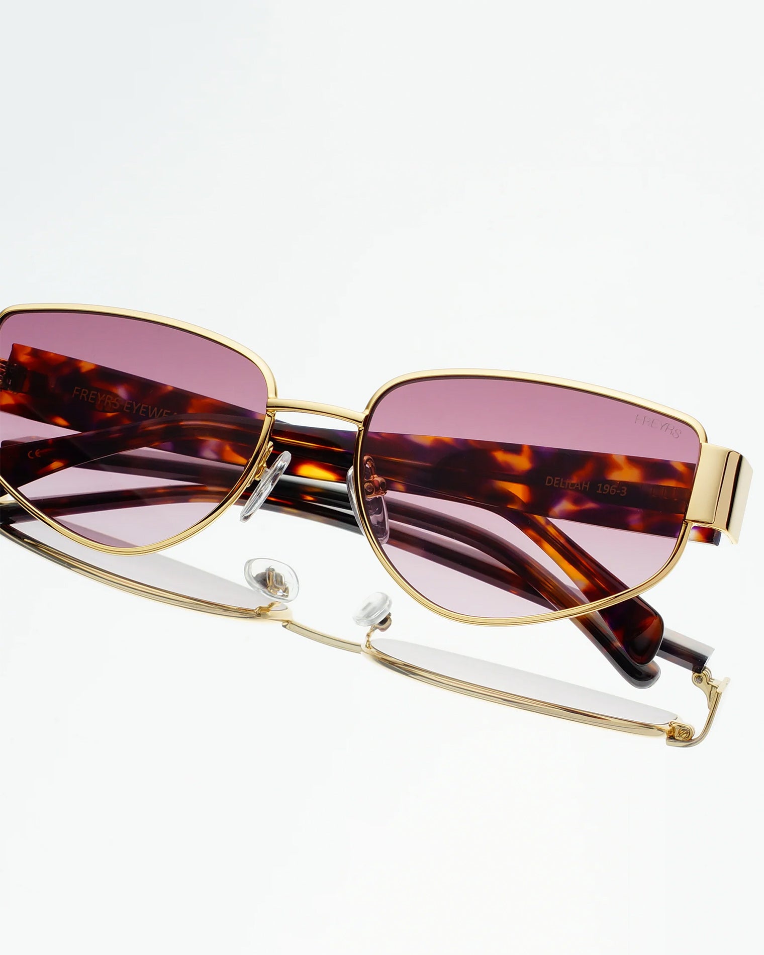 Freyrs Delilah Sunglasses - Gold Close-up detail of the Freyrs Delilah Sunglasses in gold showing the gold metal frame, tortoise arms, and pink lenses.