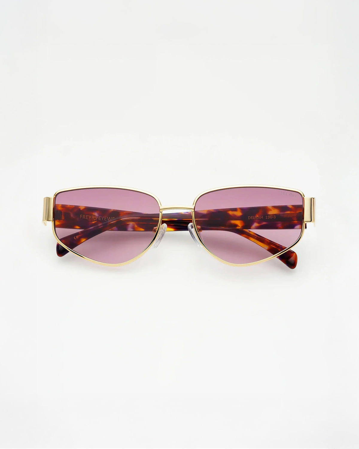 Freyrs Delilah Sunglasses - Gold Off-model image of the Freyrs Delilah Sunglasses in gold, folded flat with gold metal frame and pink-tinted lenses.