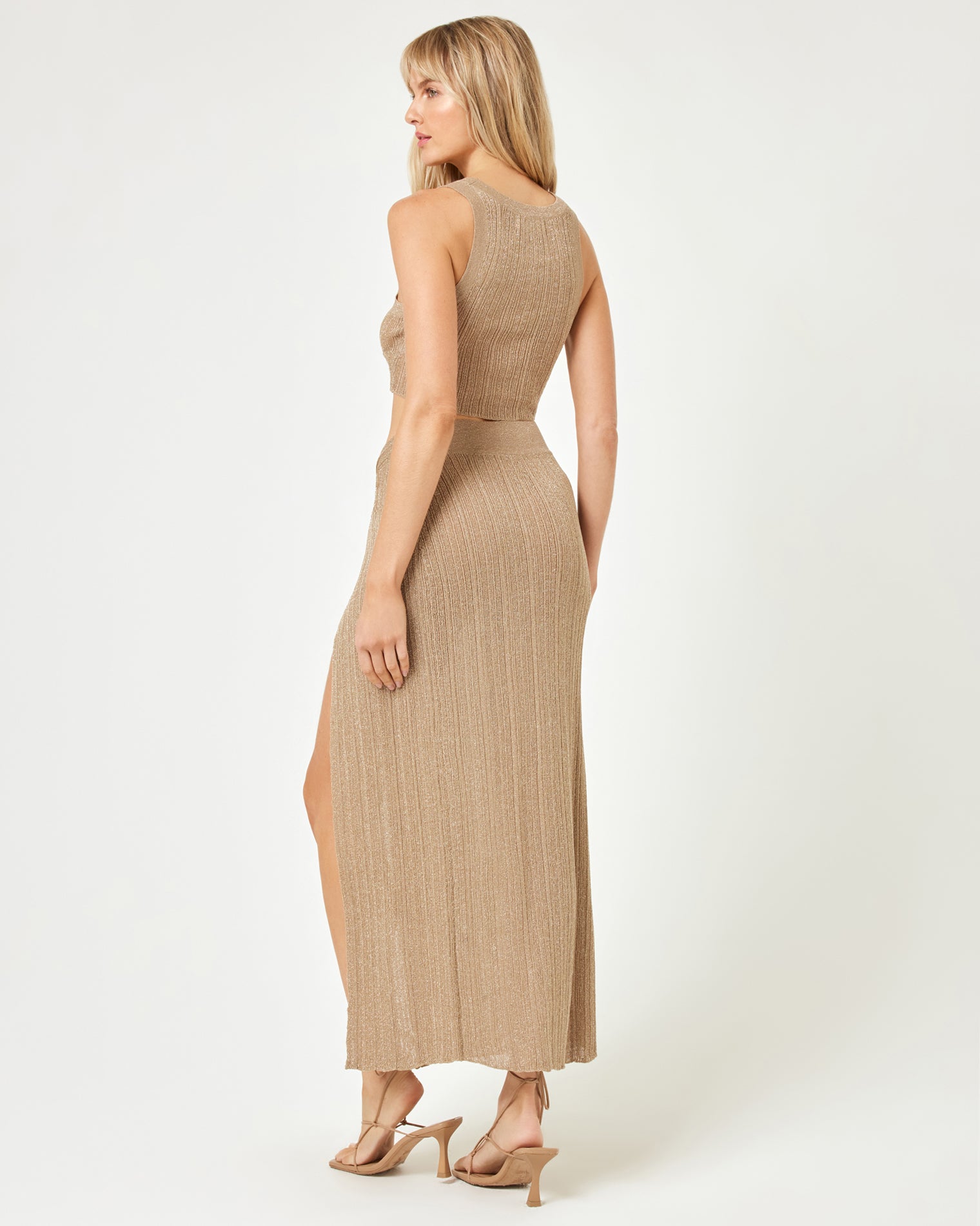 Heart Of Gold Tank - Metallic Gold Back view of a model wearing the LSPACE Heart Of Gold Tank in metallic gold, paired with the matching maxi skirt, showing the open back and racerback-style construction of the ribbed metallic knit crop top.