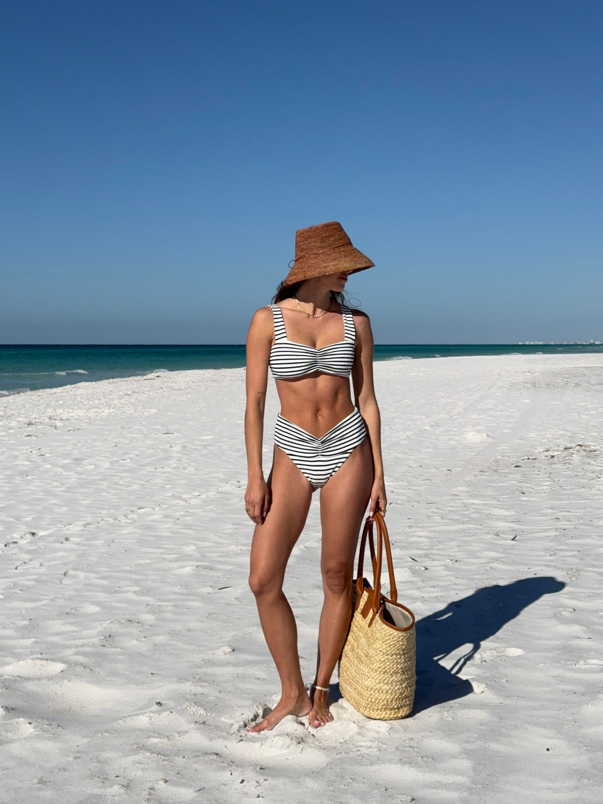Bardot Bikini Bottom - Sail Along Stripe Image of model wearing the Marlee bikini top and Bardot bikini bottom, standing in the sand.