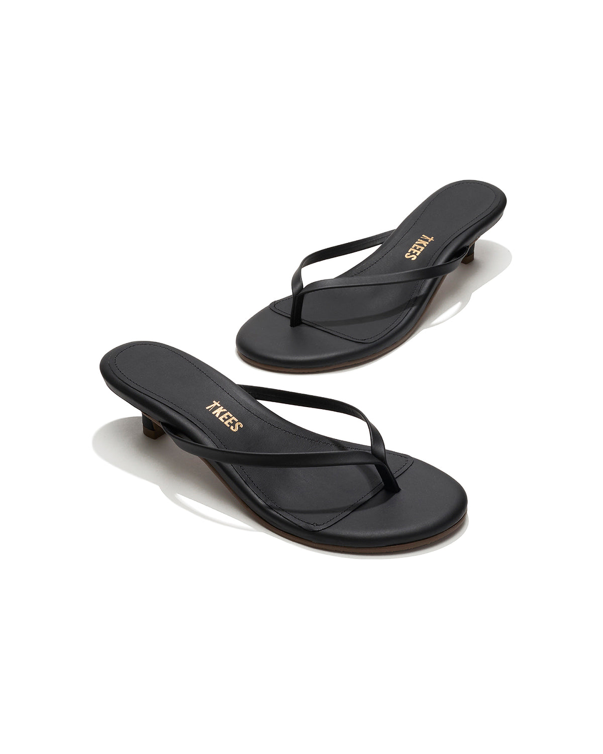 TKEES Julia Kitten Heel - Sable Angled view of both black sable leather TKEES Julia Kitten Heel thong sandals with TKEES logo.