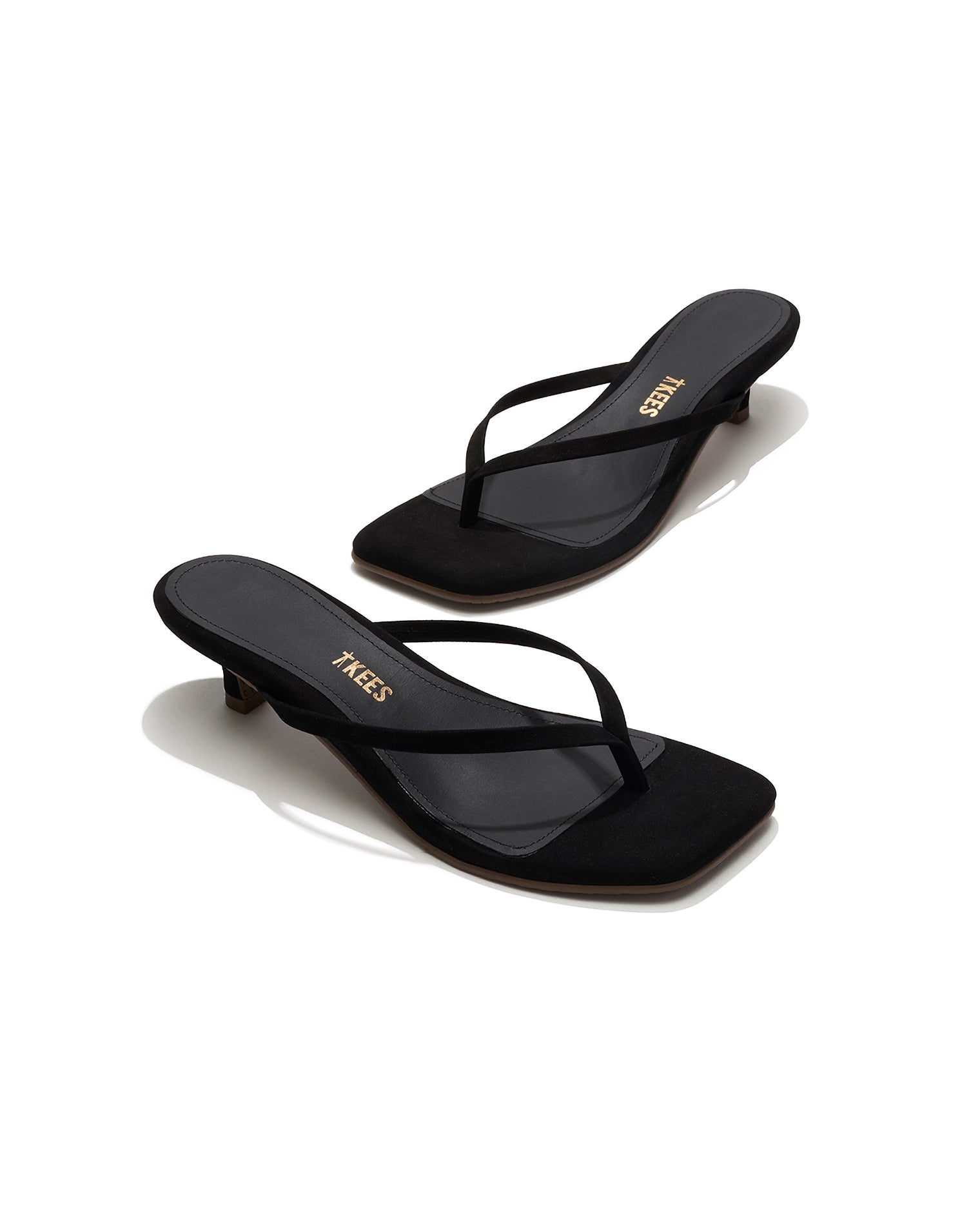TKEES Square Toe Julia Suede - Black Angled view of both black suede TKEES Square Toe Julia sandals with gold TKEES logo on footbed.