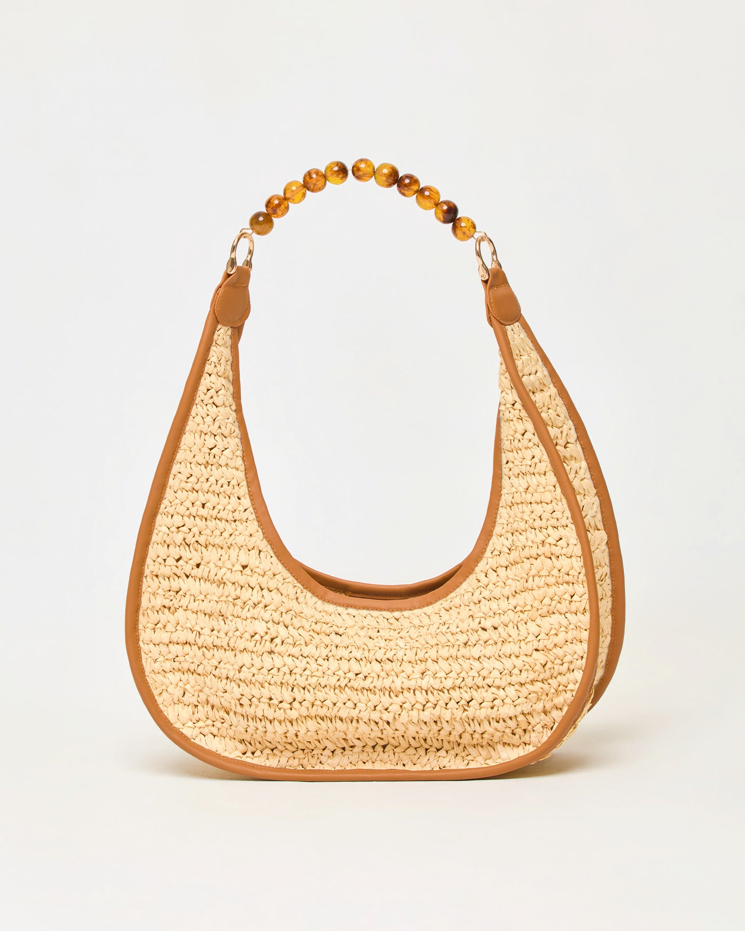 Mira Mar Bag - Natural Off-model front view of the natural Mira Mar Bag, a crescent-shaped raffia bag with brown leather trim and amber bead handle.