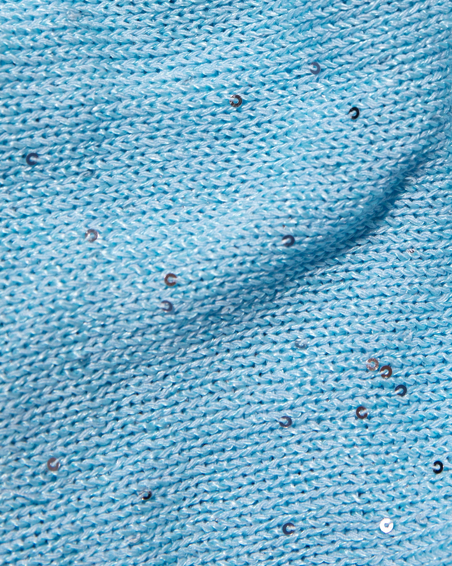 Last Light Skirt - Sky Blue A close-up of light blue knit fabric with scattered small reflective sequins.