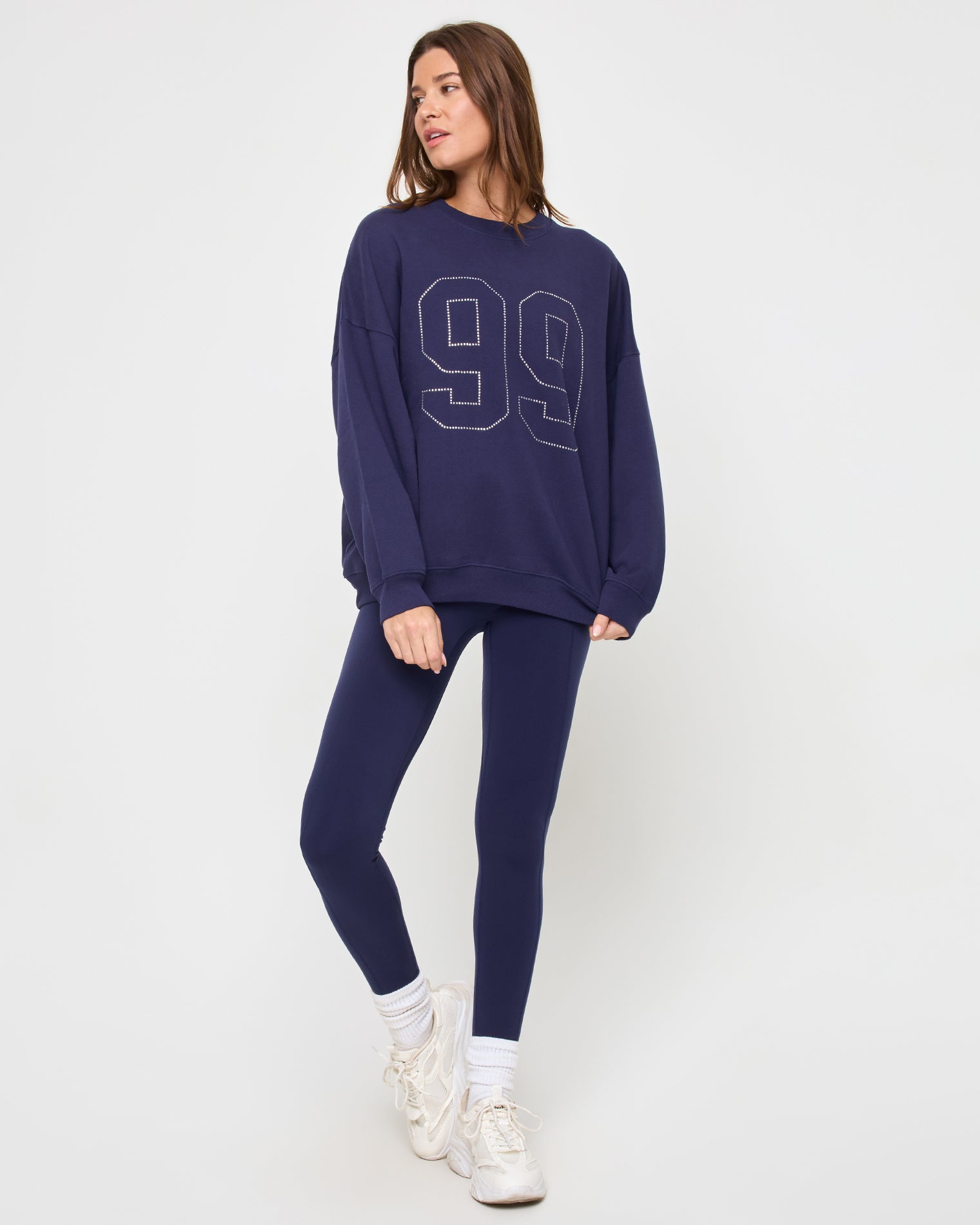 Legend Sweatshirt - Midnight Blue Front view of the LSPACE Legend Sweatshirt in midnight blue on a model against a light background, showing the cropped oversized sweatshirt with rhinestone graphic detail.